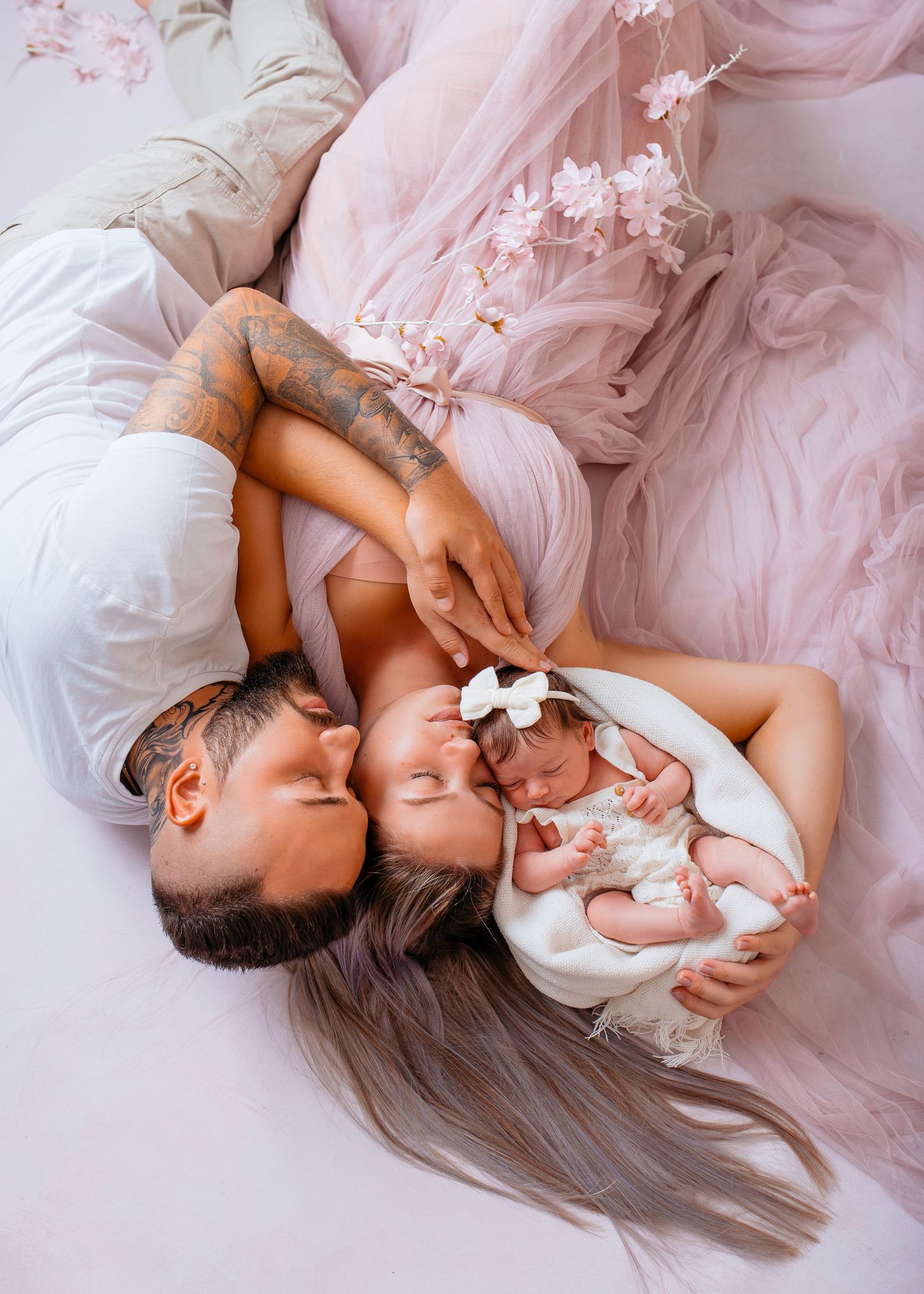 Mutter und Vater liegen mit ihrem Baby im Studio – natürliche Newbornfotografie in Nürnberg