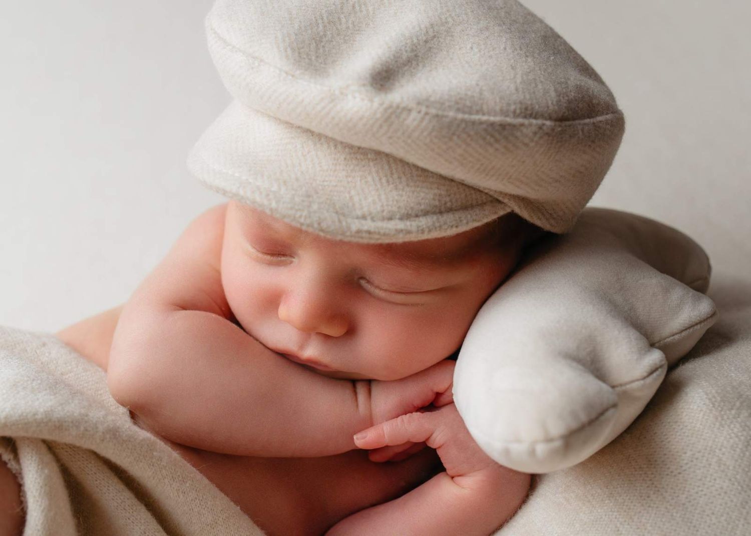 Schlafendes Neugeborenes mit Mütze im Studio – ruhige Newbornfotografie in Nürnberg