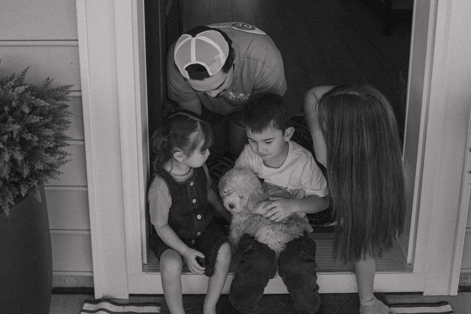 timeless candid photo. Family lifestyle income shoot. siblings hugging. Family dog. Family of four.