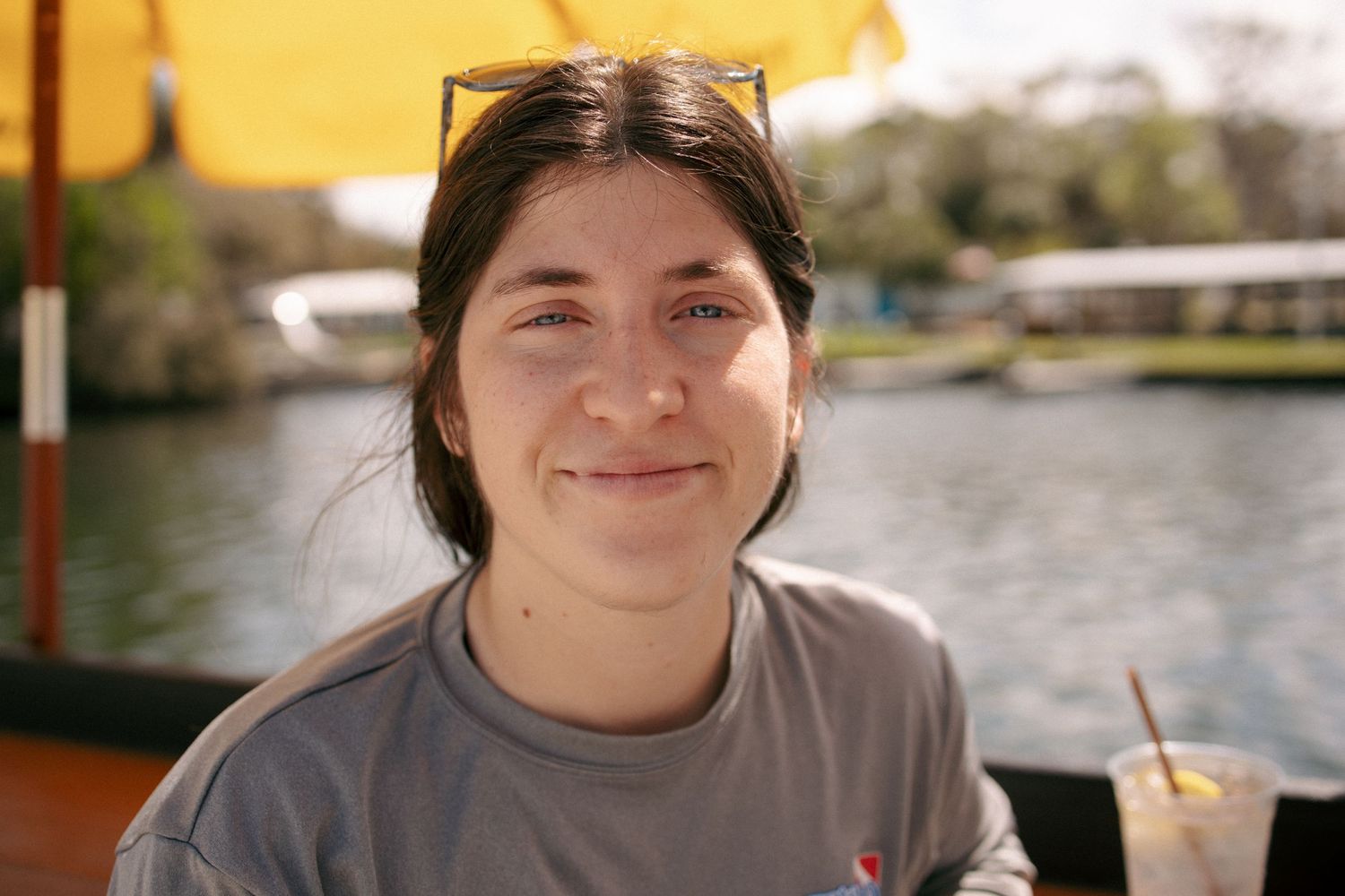 A collage of candid outdoor portraits showing someone smiling by a waterfront setting in warm sunlight.
