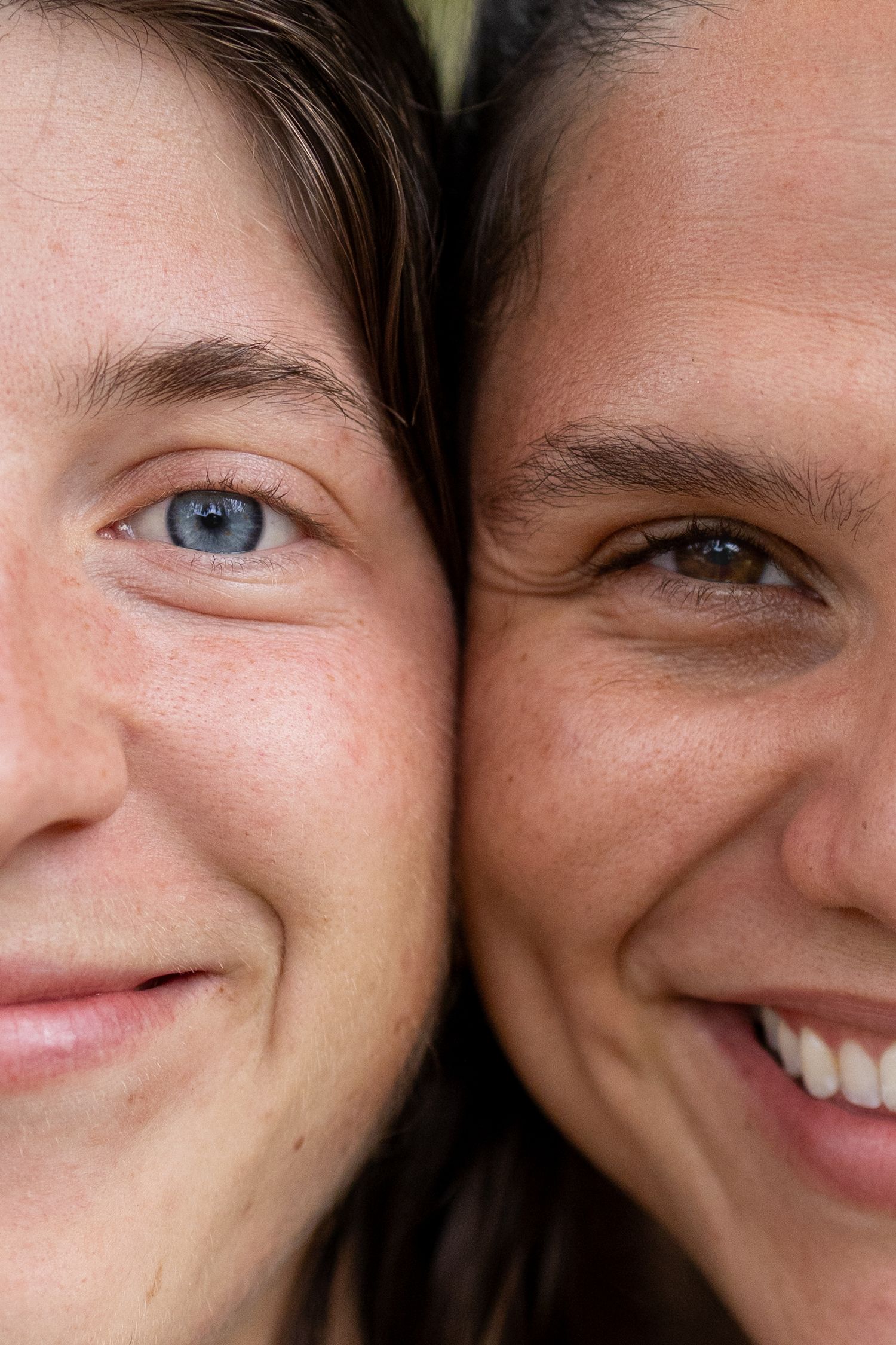 Extreme close-up photo showing smiling expressions and different colored eyes.