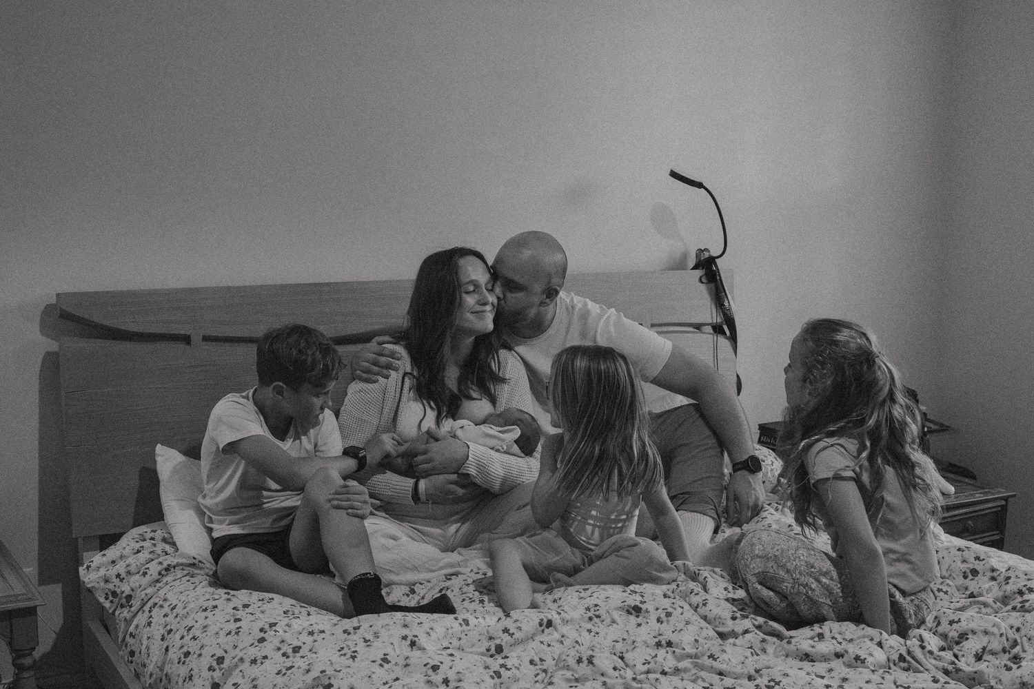 A series of black and white photographs showing intimate moments between a couple laying on a bed.