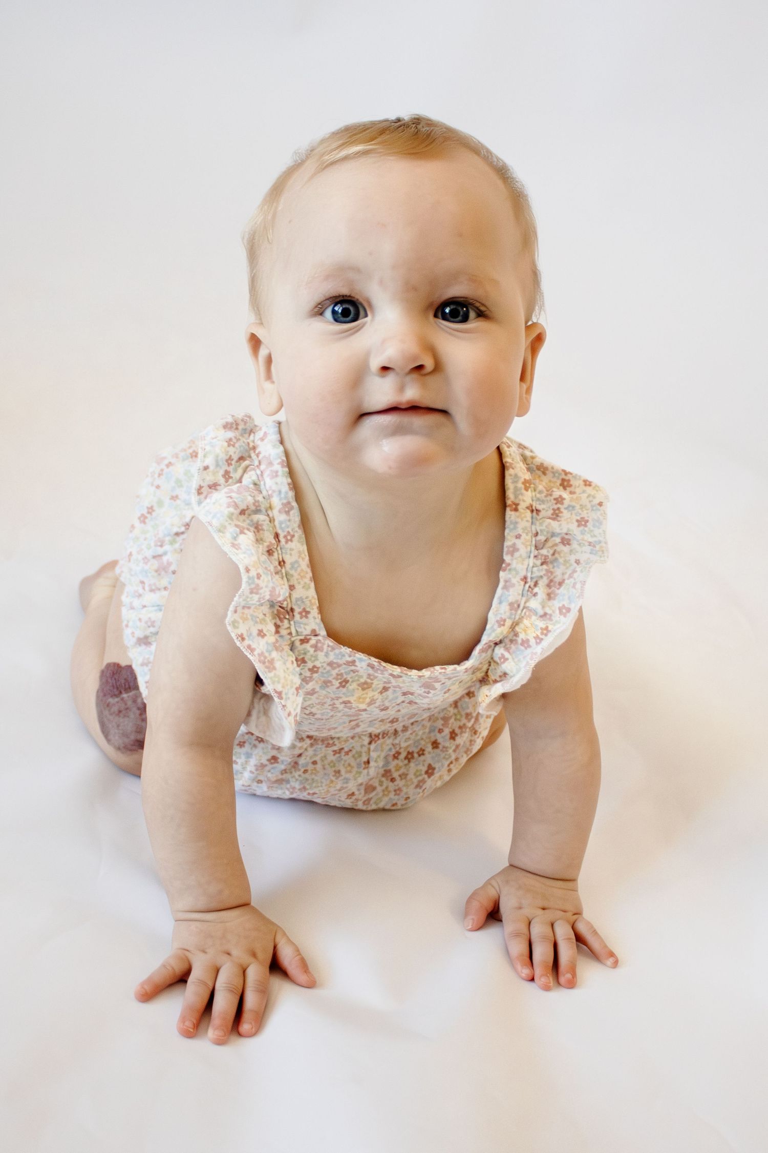 candid children's studio photography. Happy child posing in front of a white backdrop. Children's milestone photography in florence arizona