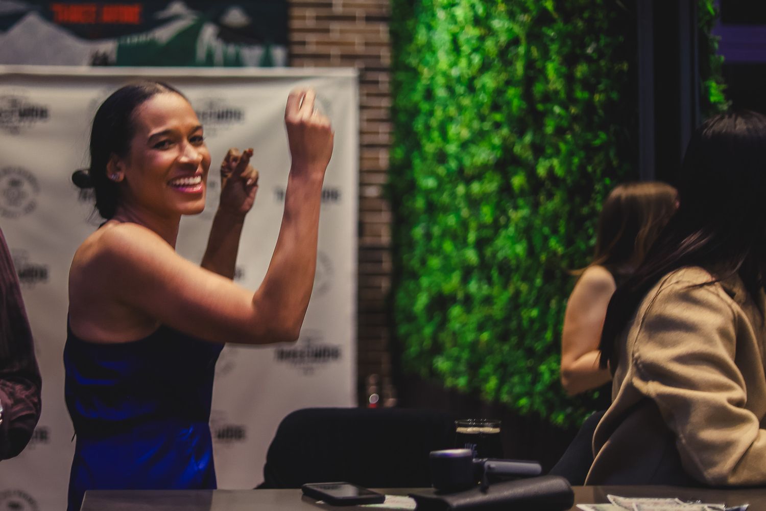 Woman smiling and gesturing at Three Wide Brewing Co event in Fort Worth Texas.
