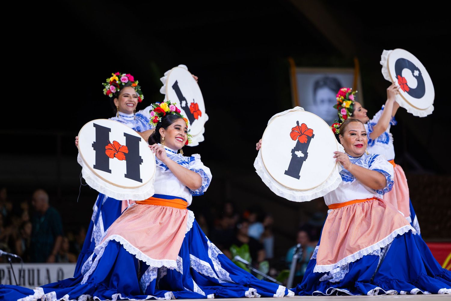 Traditional dancers in colorful costumes perform a choreographed routine with spinning movements and flowing dresses.