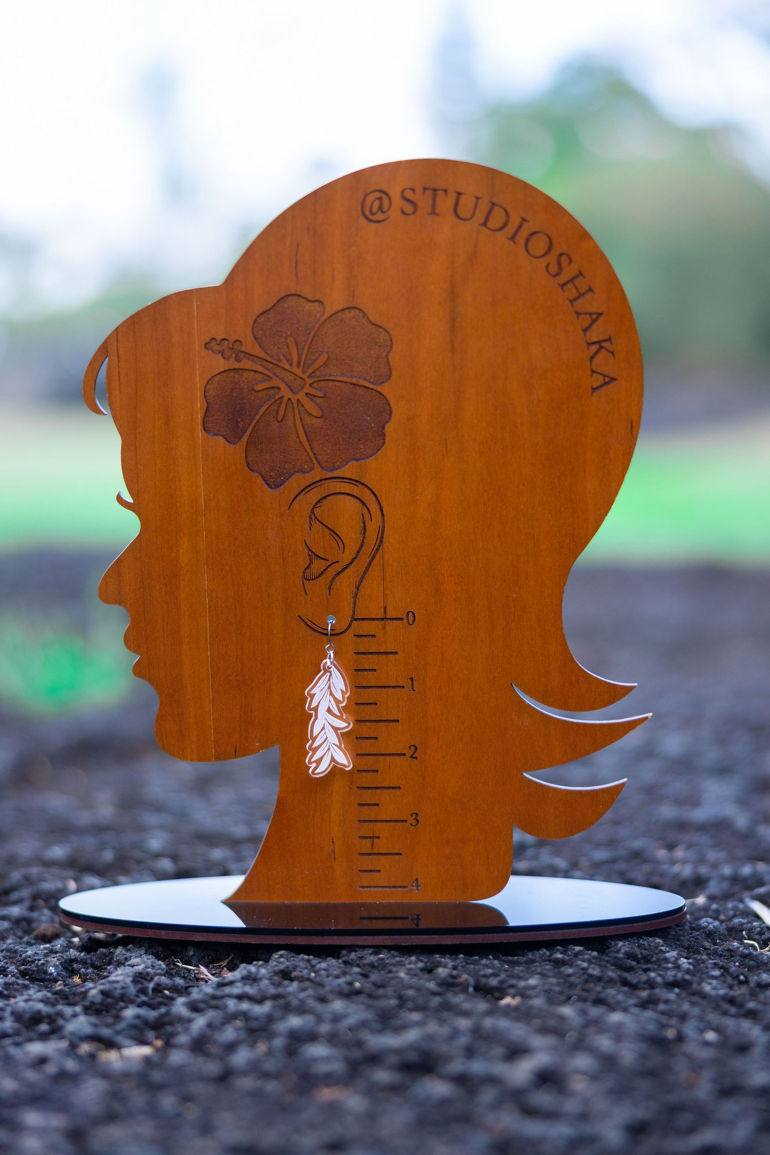 Wooden silhouette cutout with hibiscus flower design displayed on dark surface.