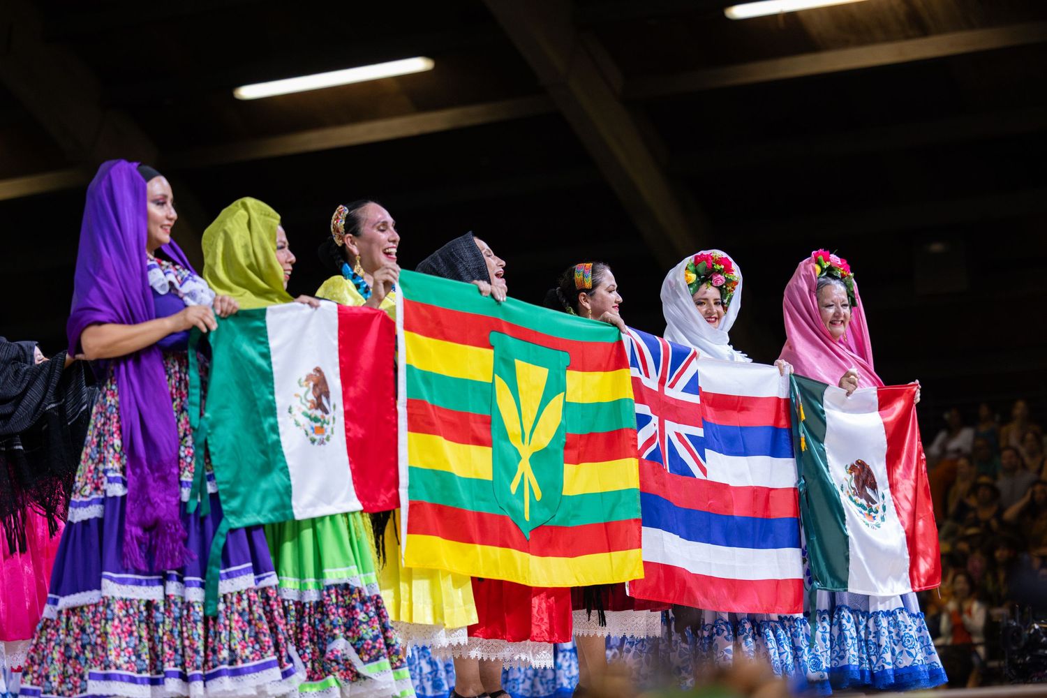 Athletes stand together holding national flags during an international sporting event ceremony.