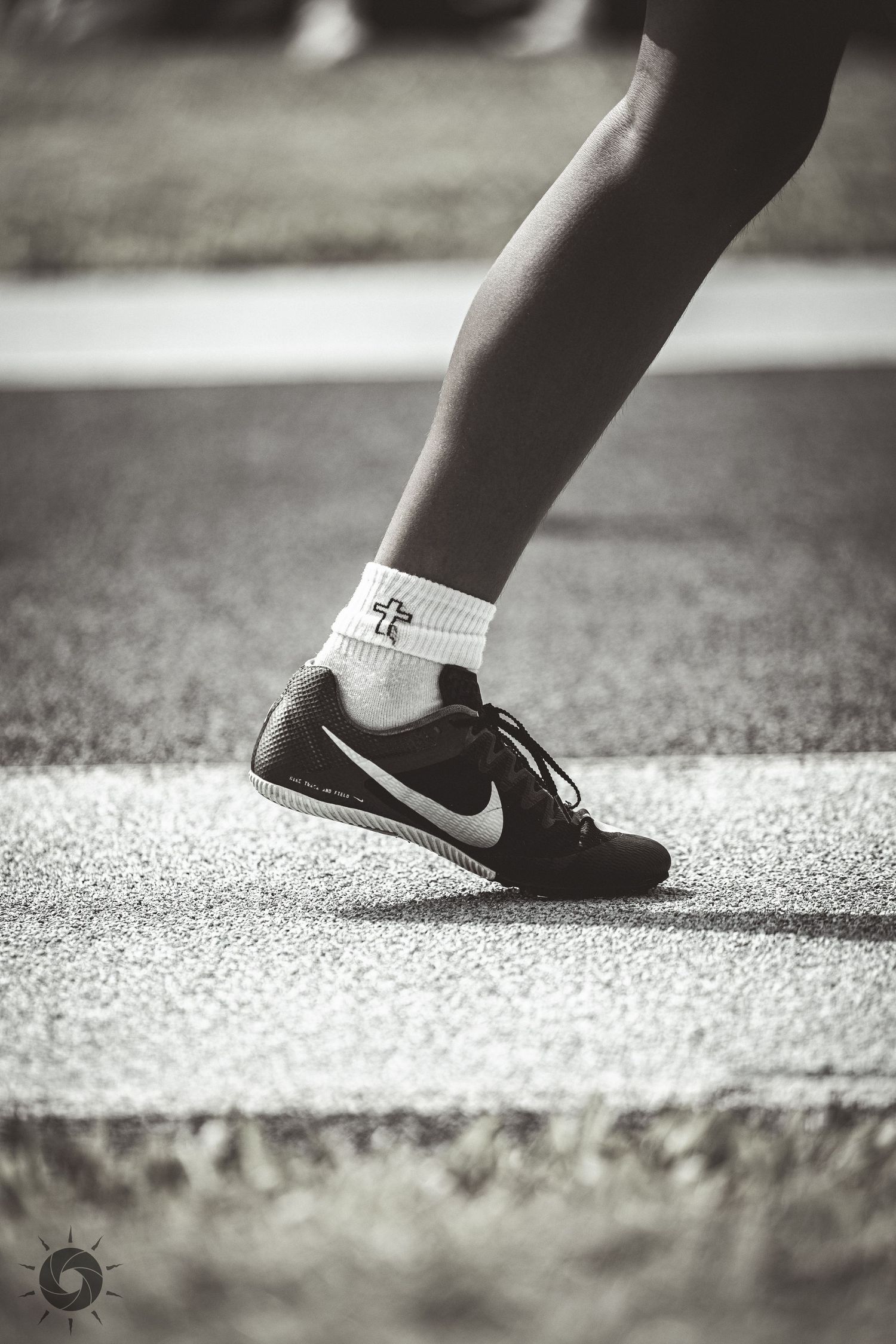 A close-up sequence of black Nike sneakers walking on a textured concrete surface in black and white photography.