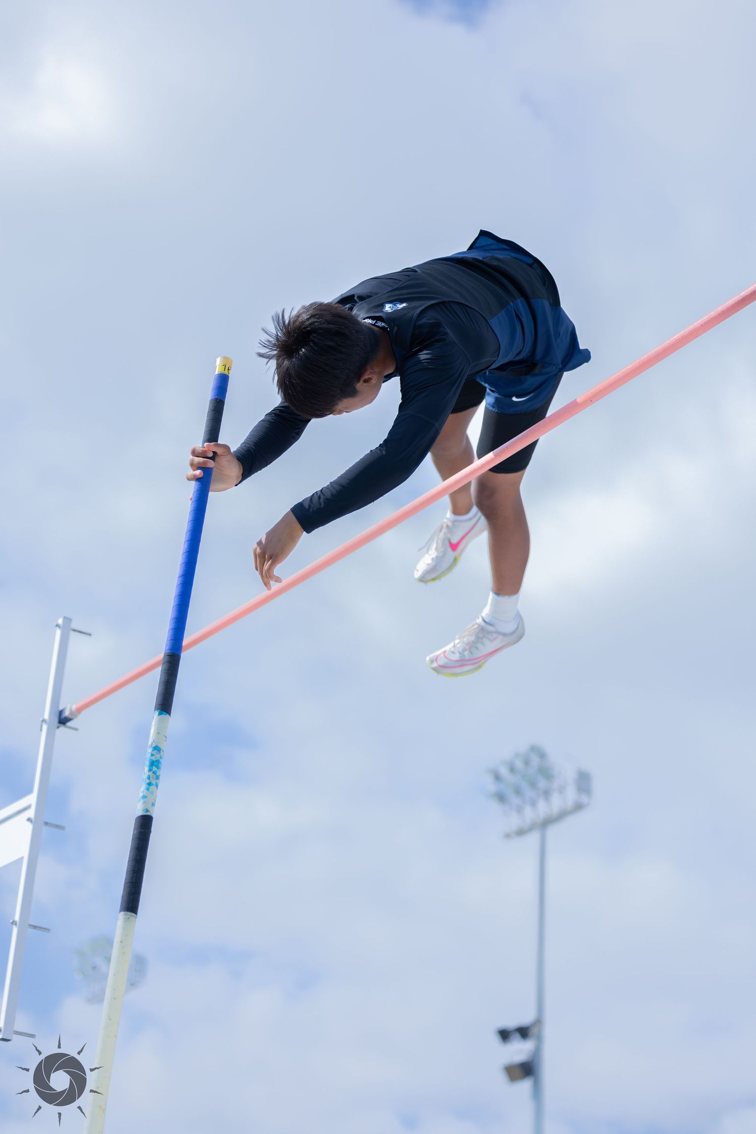Sequence of pole vaulting action shots showing an athlete clearing the bar against a cloudy sky background.