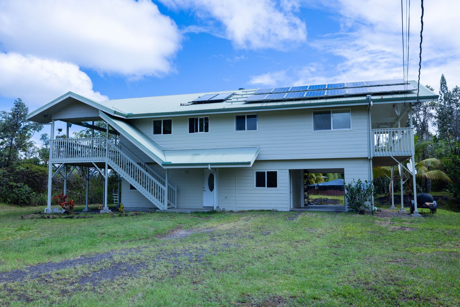 Long single-story ranch house with blue roof under bright sky.