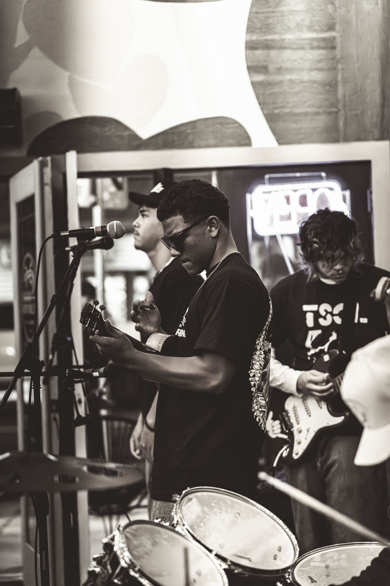 Black and white images of band members performing with instruments in an intimate venue setting.