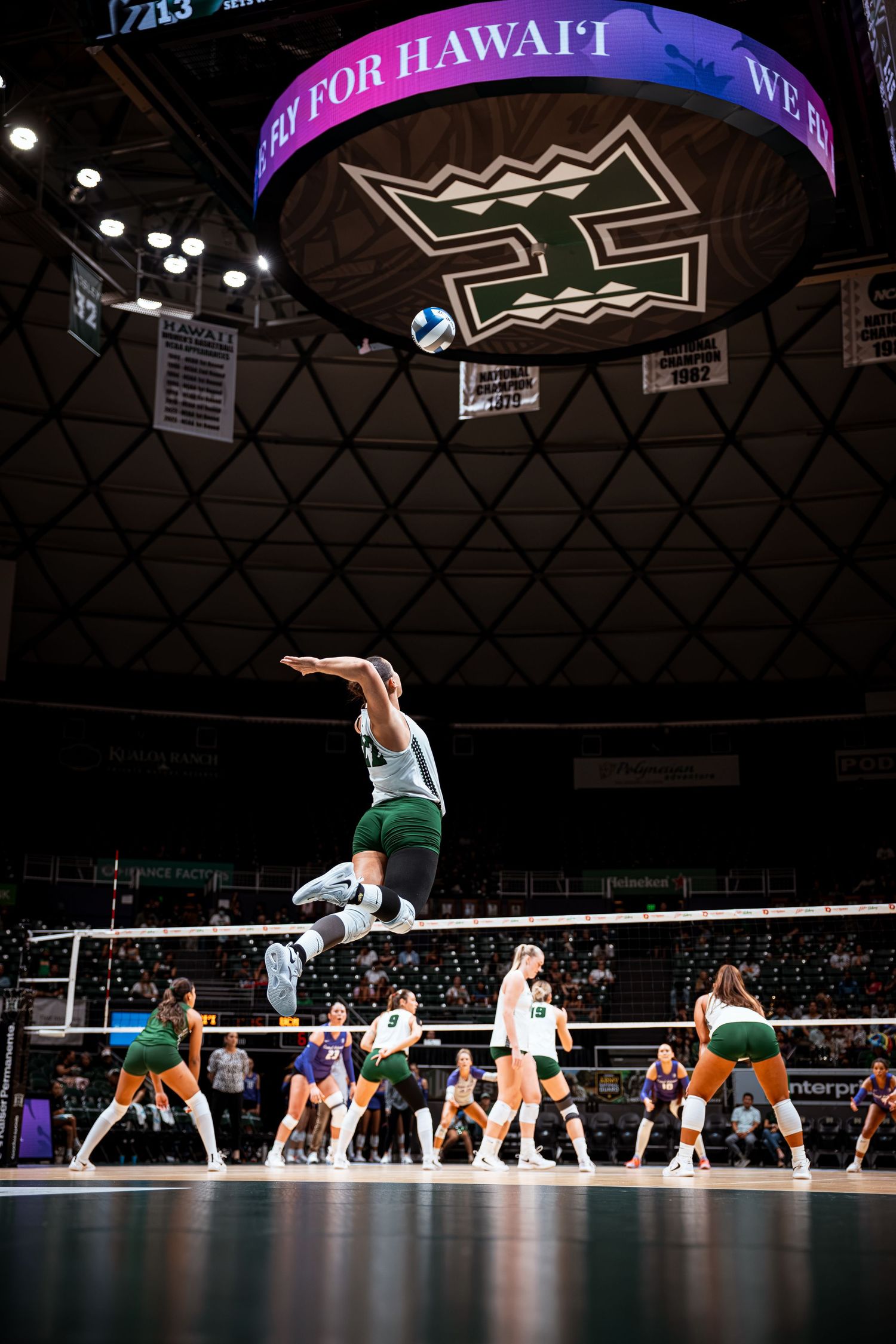 Hawaii Rainbow Wahine volleyball player jumps to spike the ball during a match at the Stan Sheriff Center.