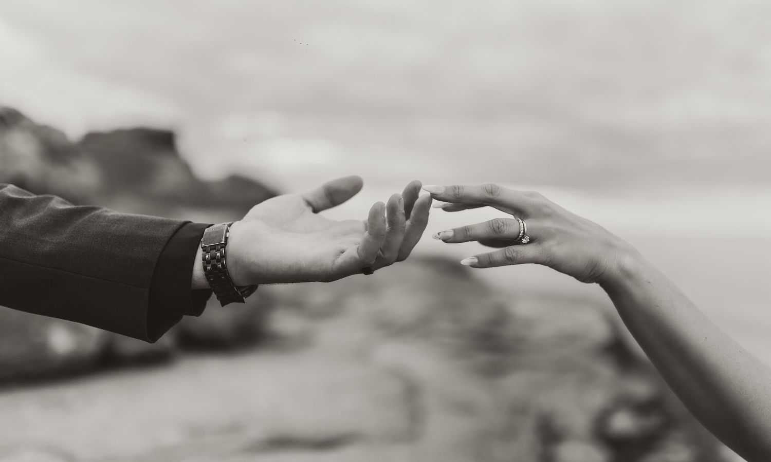 black and white photo of two hands slightly touching