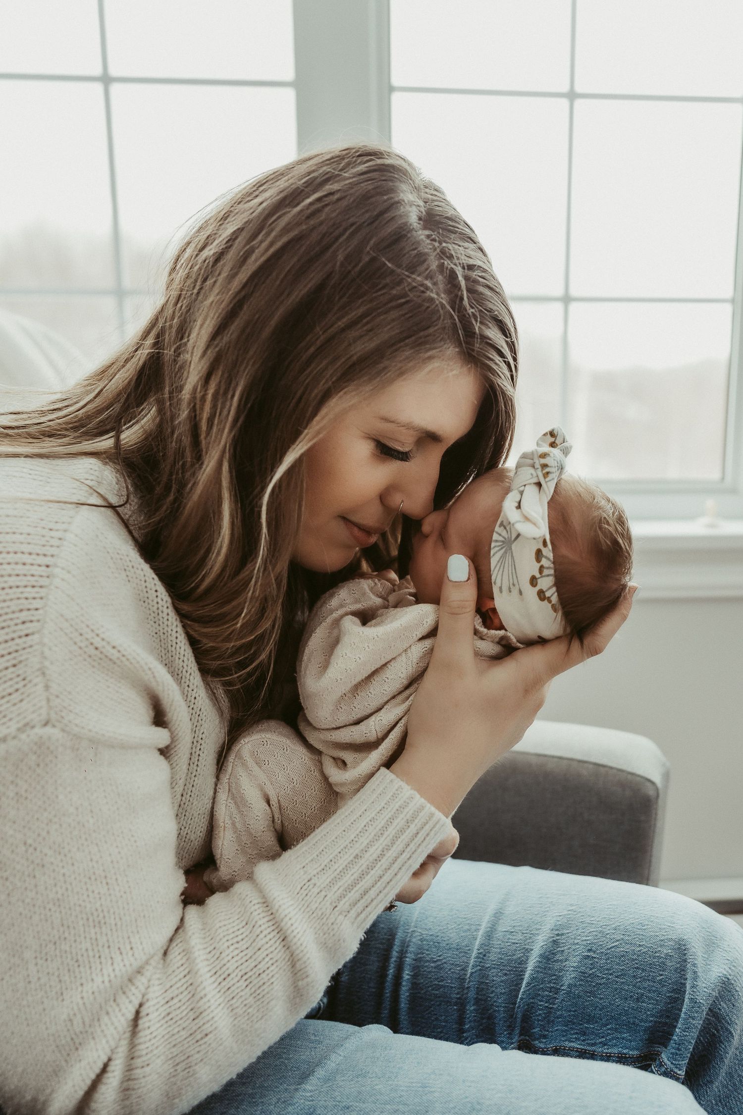mother snuggling her newborn baby photoshoot
