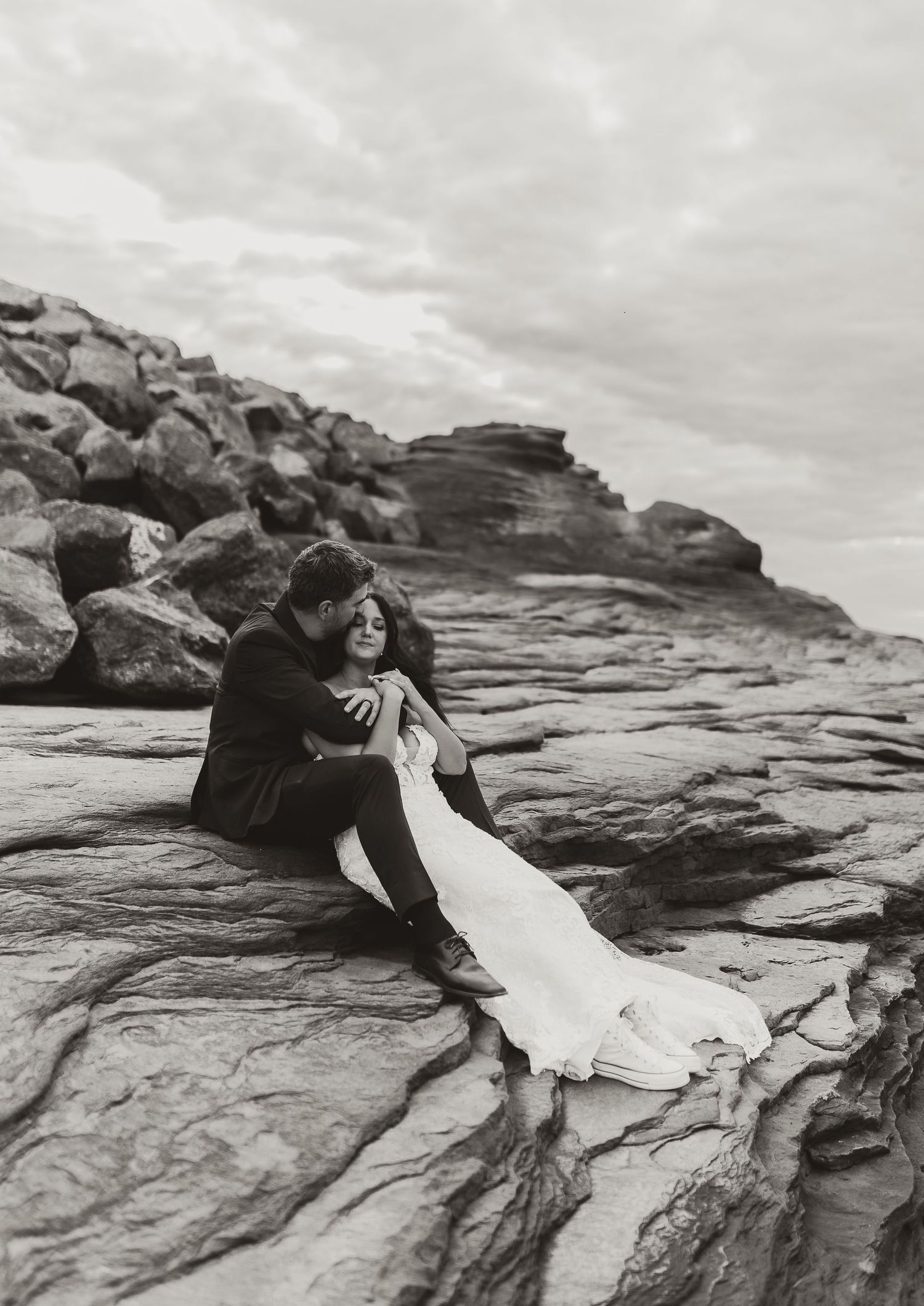 black and white bride and groom on rocky beach in cap pele NB