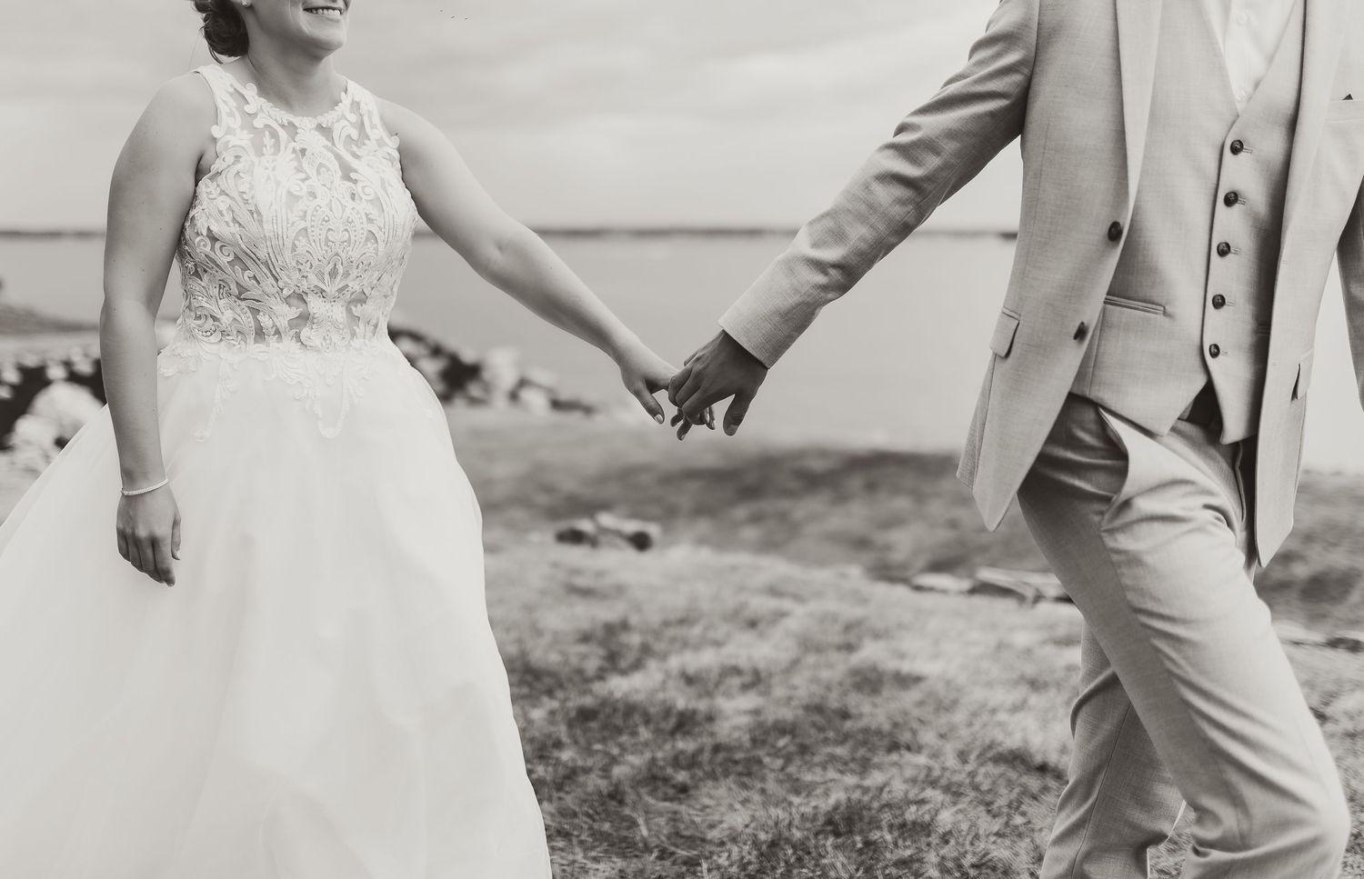 black and white photograph of bride and groom holding hands in New Brunswick