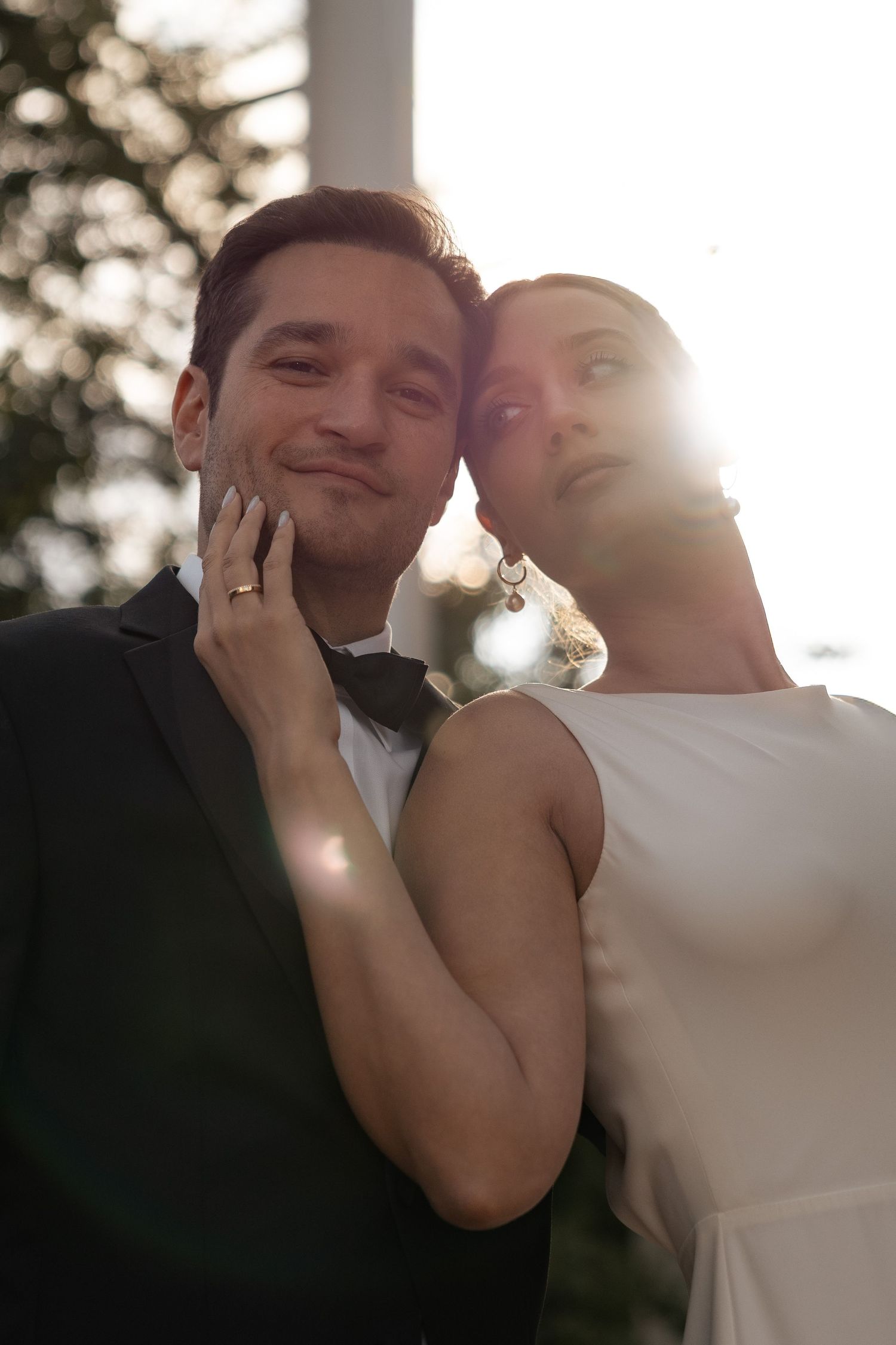 Newlyweds sharing an intimate moment beneath warm evening lights