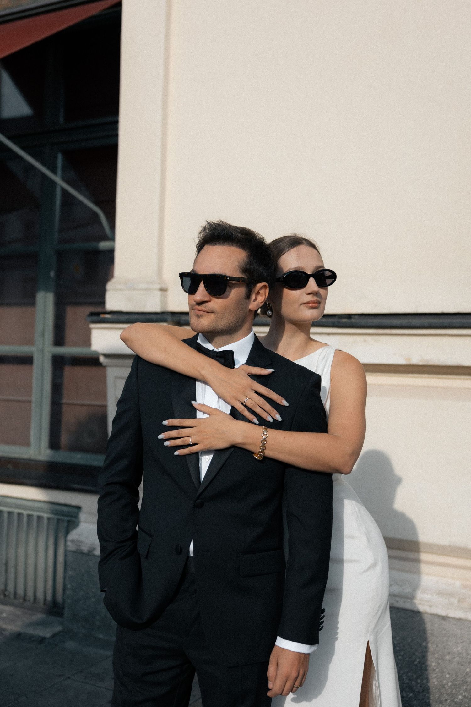 Newlyweds walking through the city wearing sunglasses