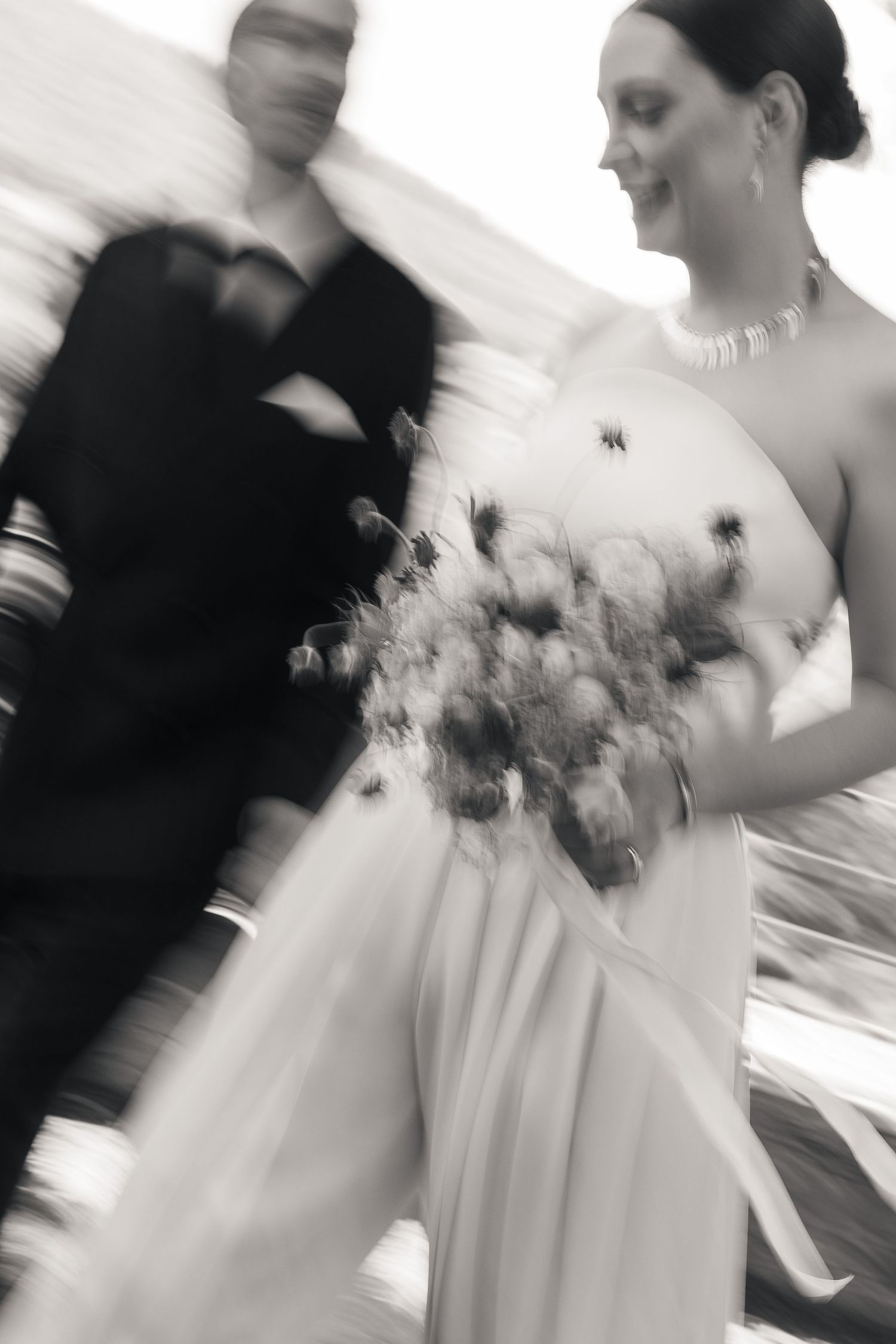 Motion blur black and white frame of newlyweds walking in a park