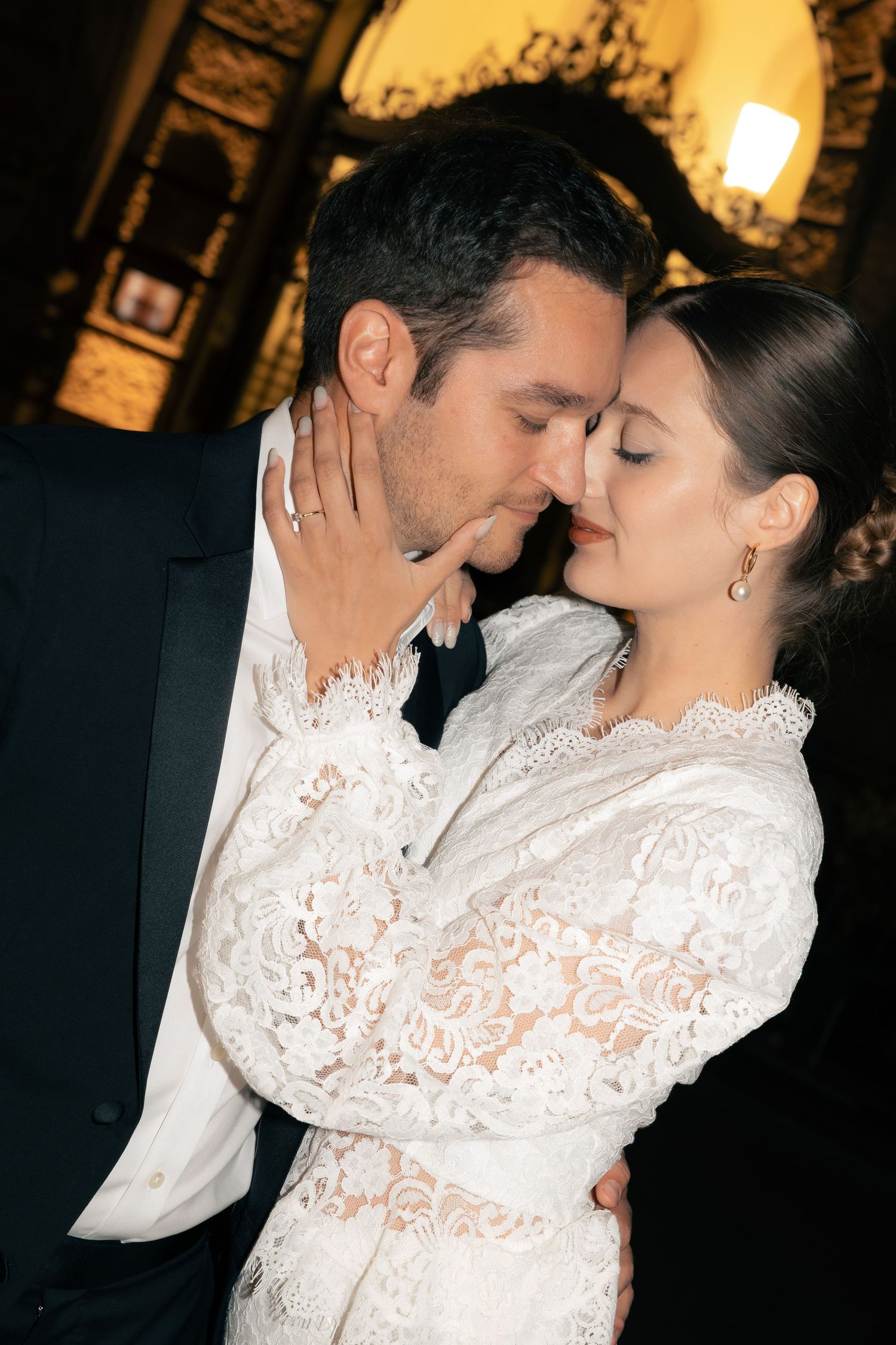 Newlywed couple in loving gesture in the city at night