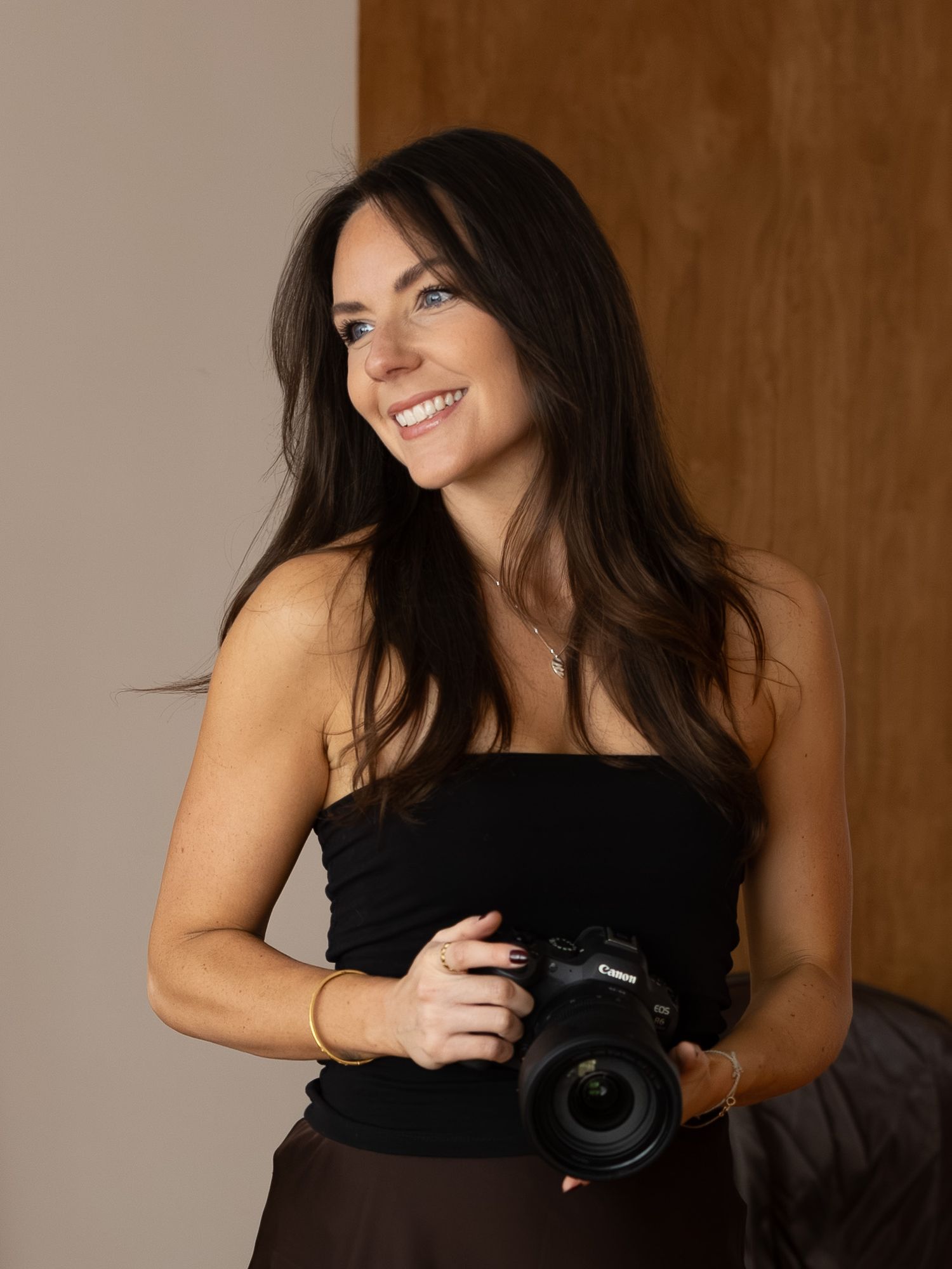 Smiling photographer Caro holding her camera in her hands