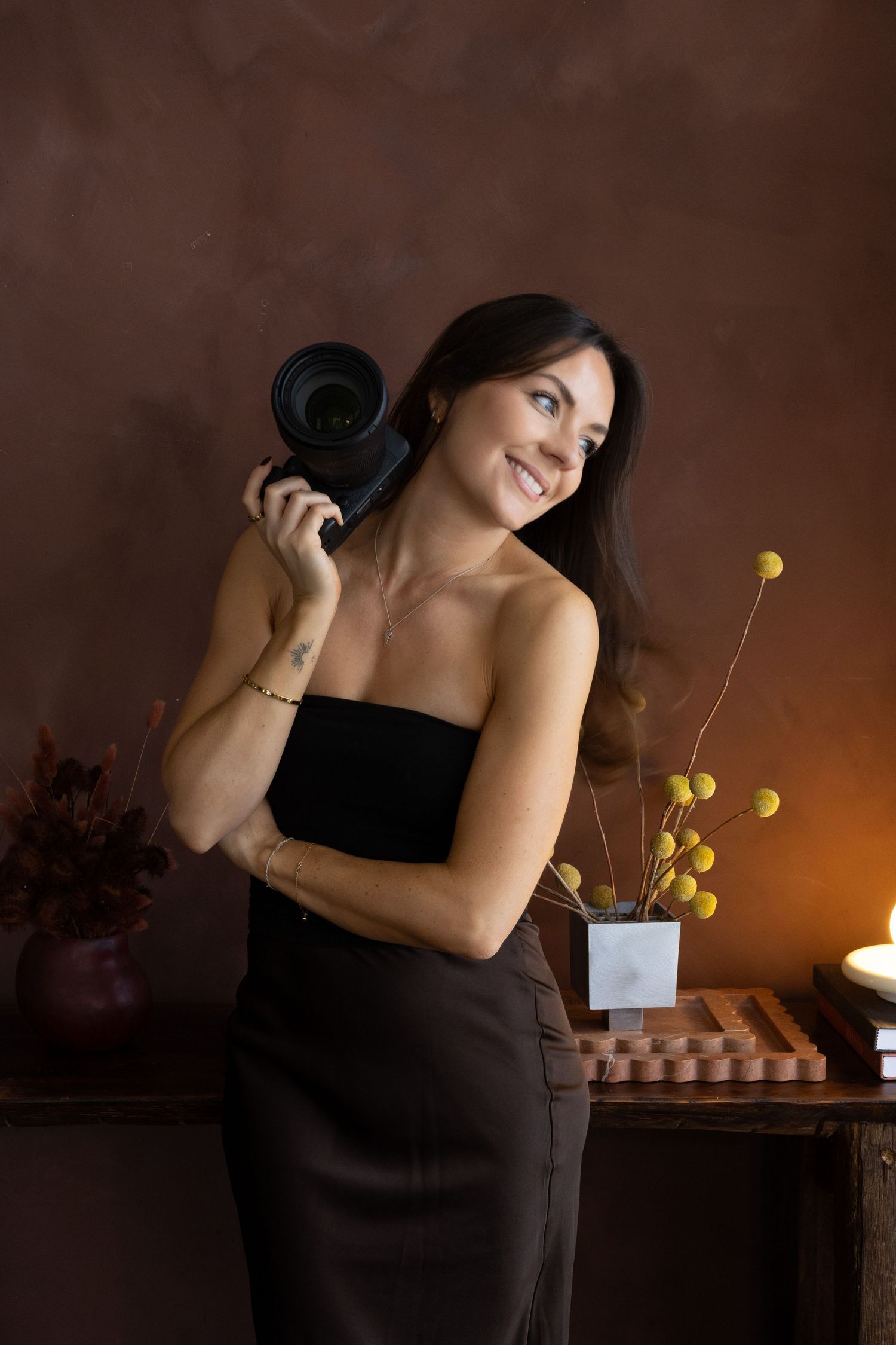 Smiling photographer Caro holding her camera in her hand