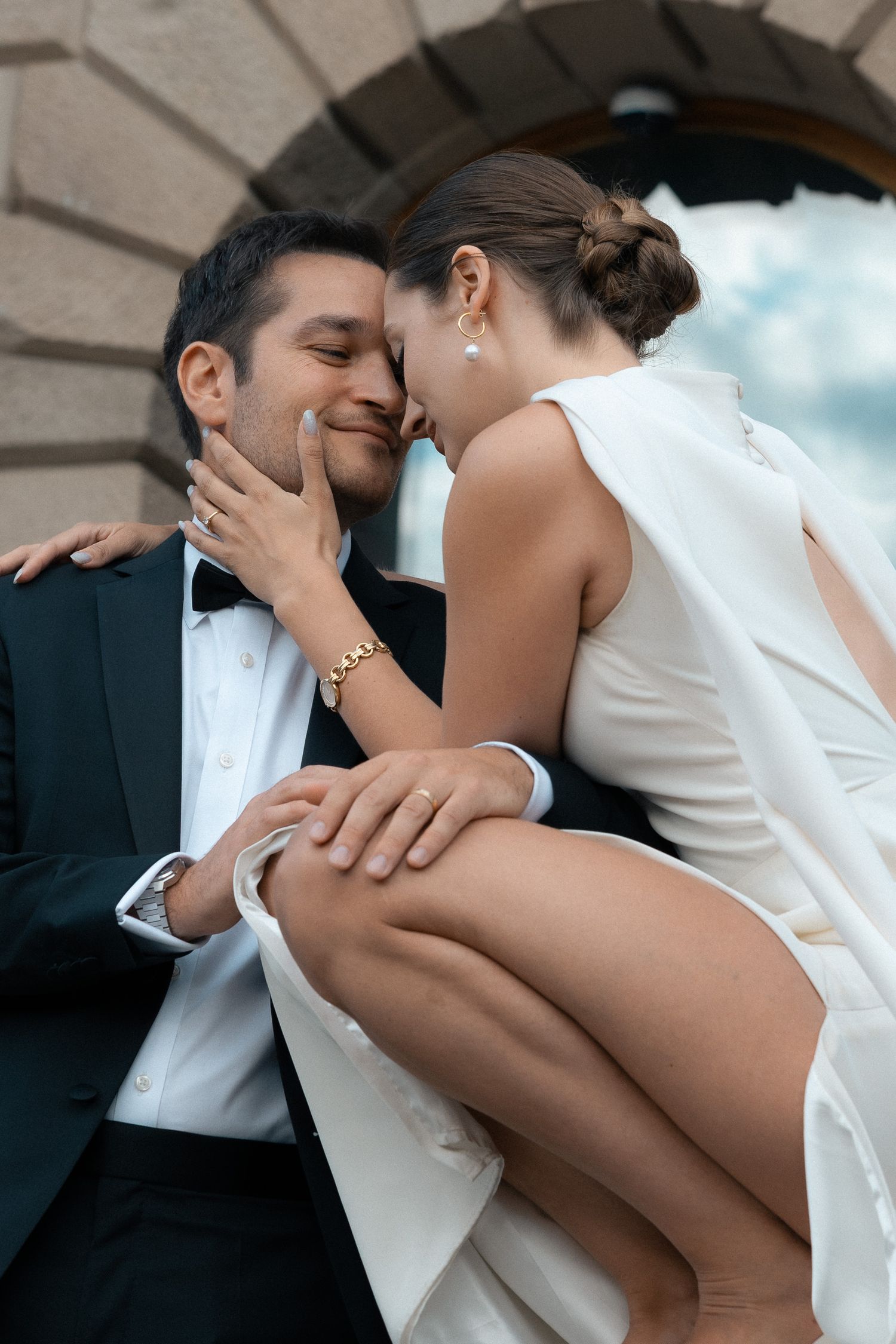 Couple leaning in for a kiss in front of historic building