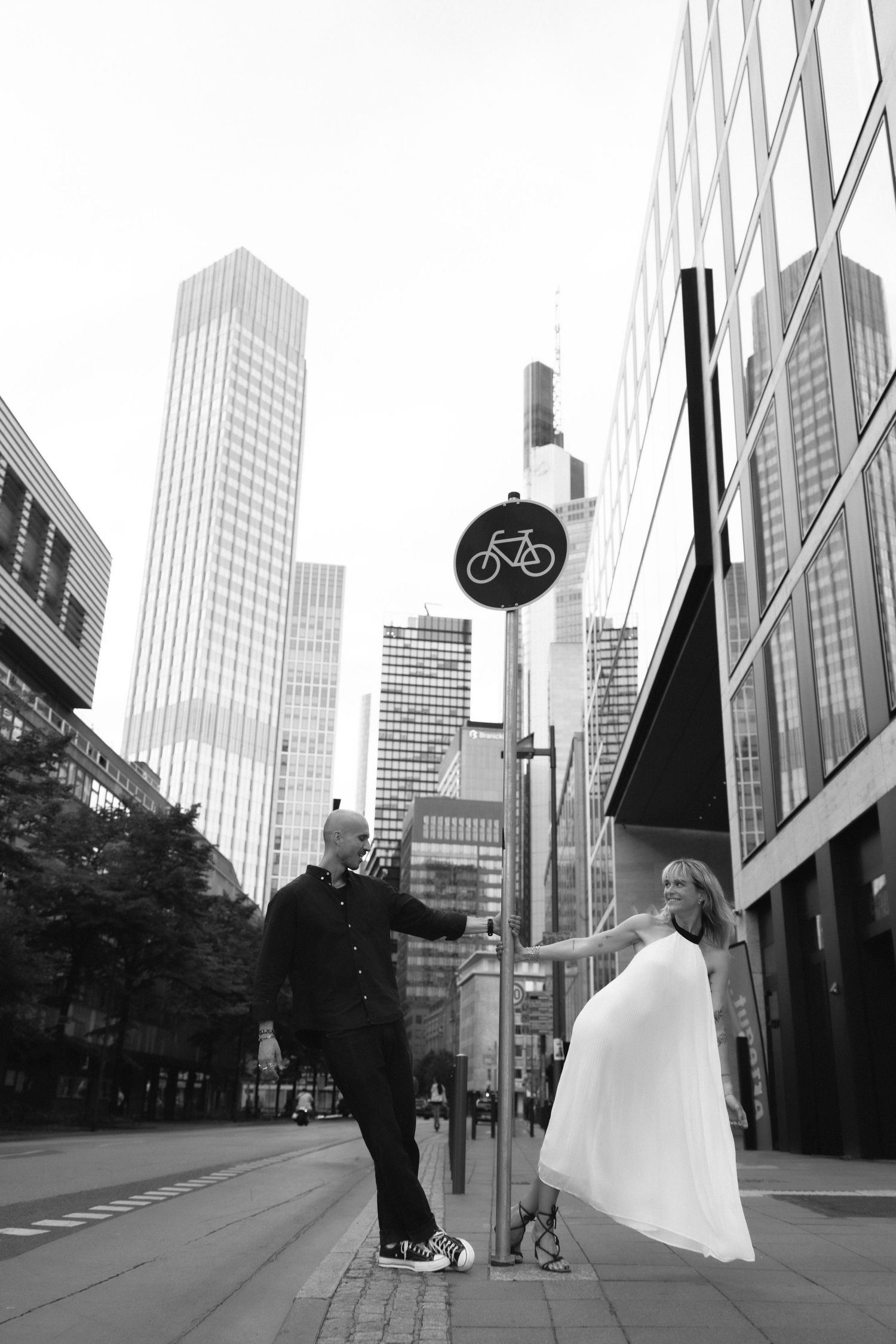 Couple playing together on a city street surrounded by skyscrapers