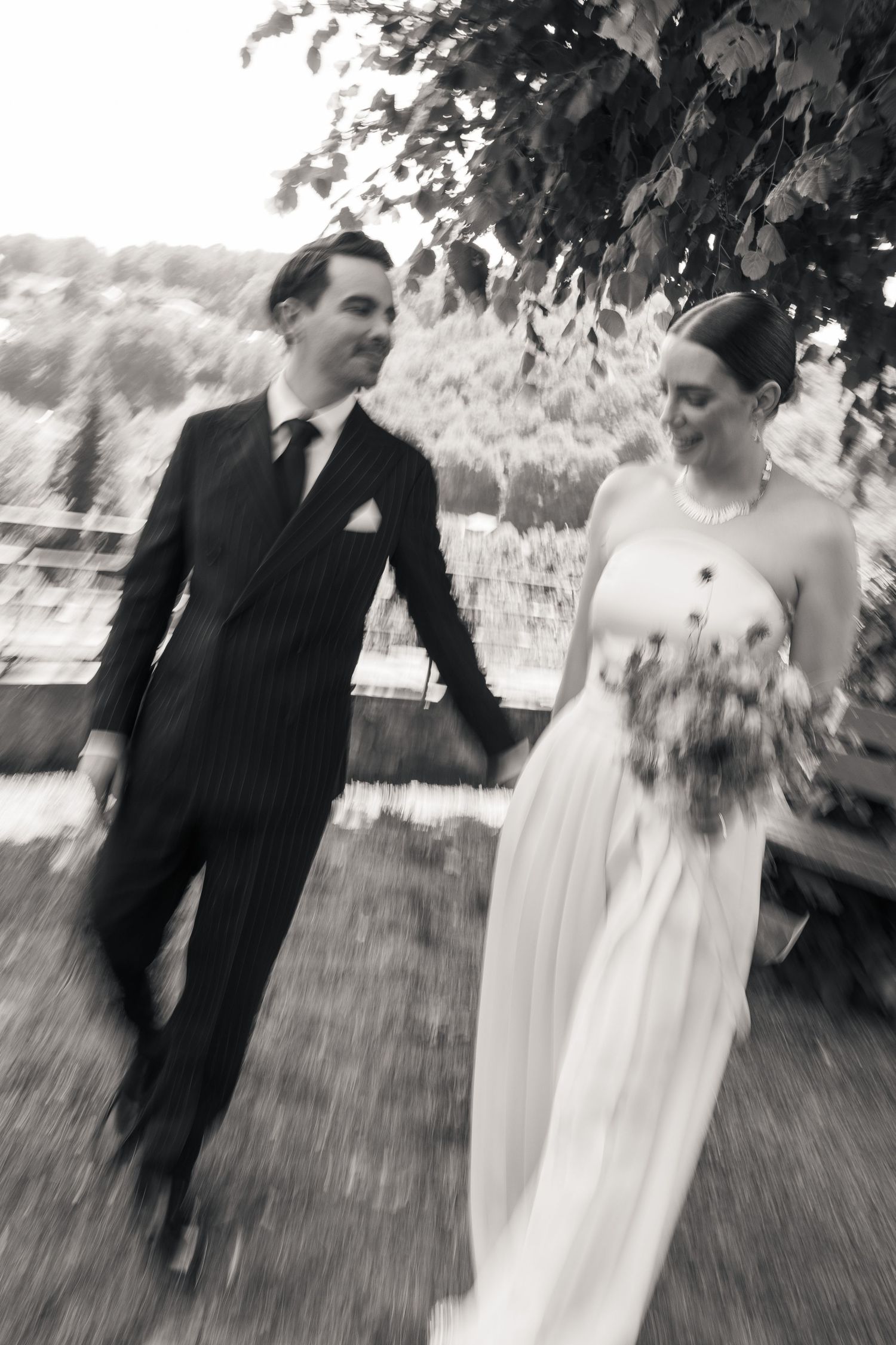 Motion blur black and white frame of newlyweds walking in a park