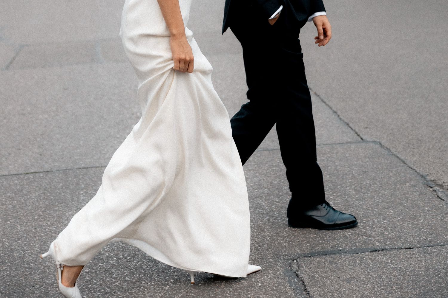 Bride and groom walking together in a cropped editorial photograph