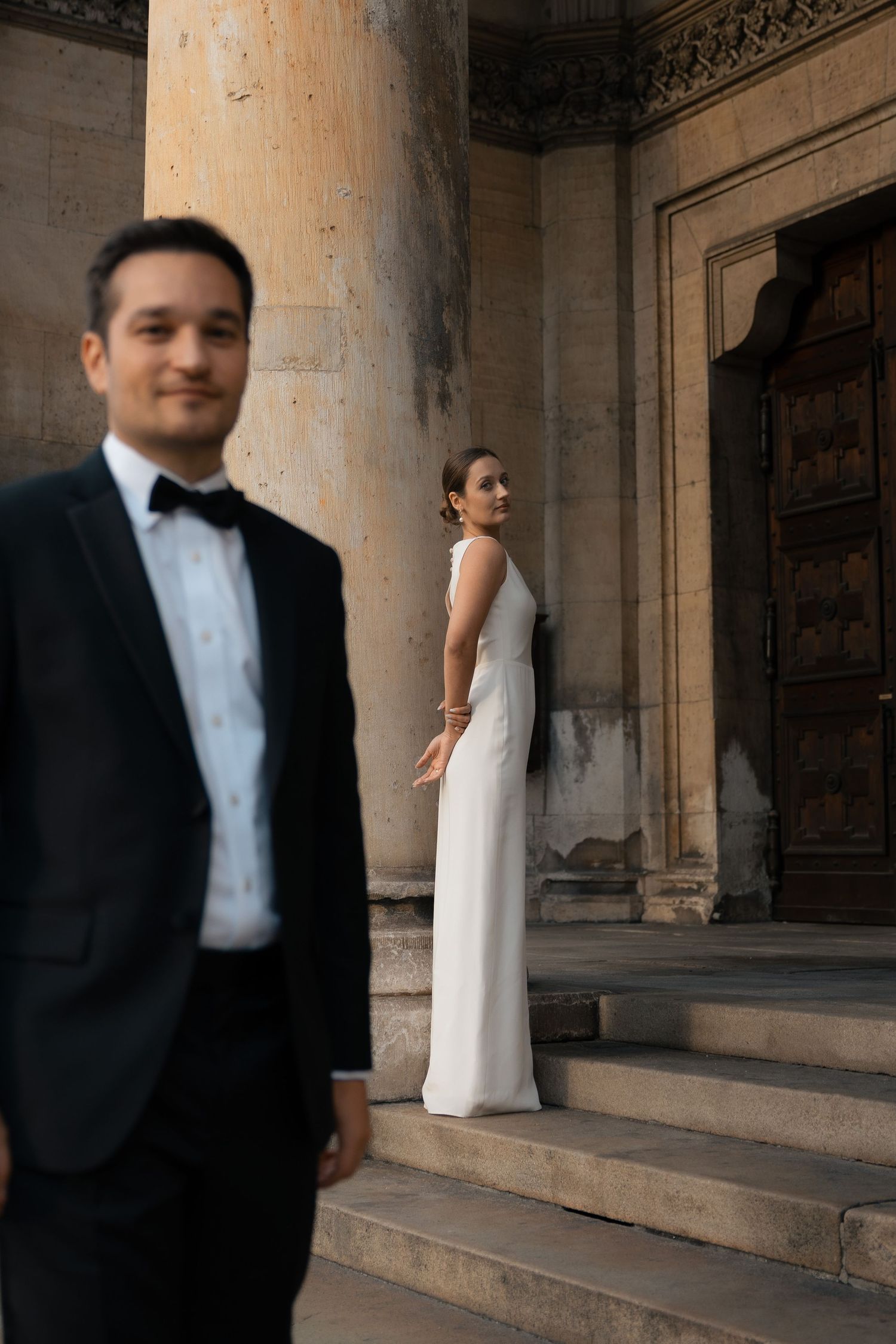 Bride and groom walking together along a historic stone staircase
