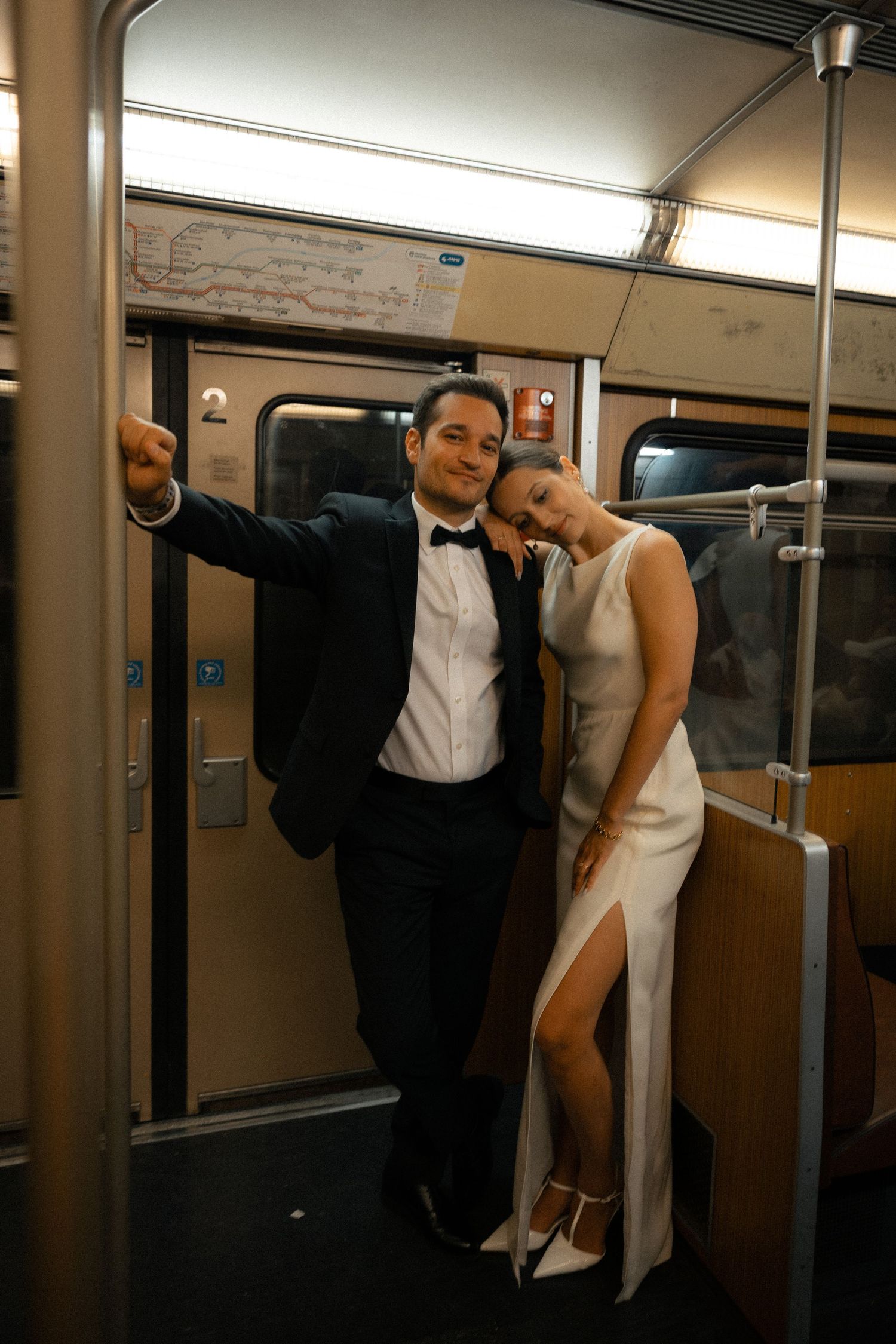 Newlyweds leaning together inside a city train