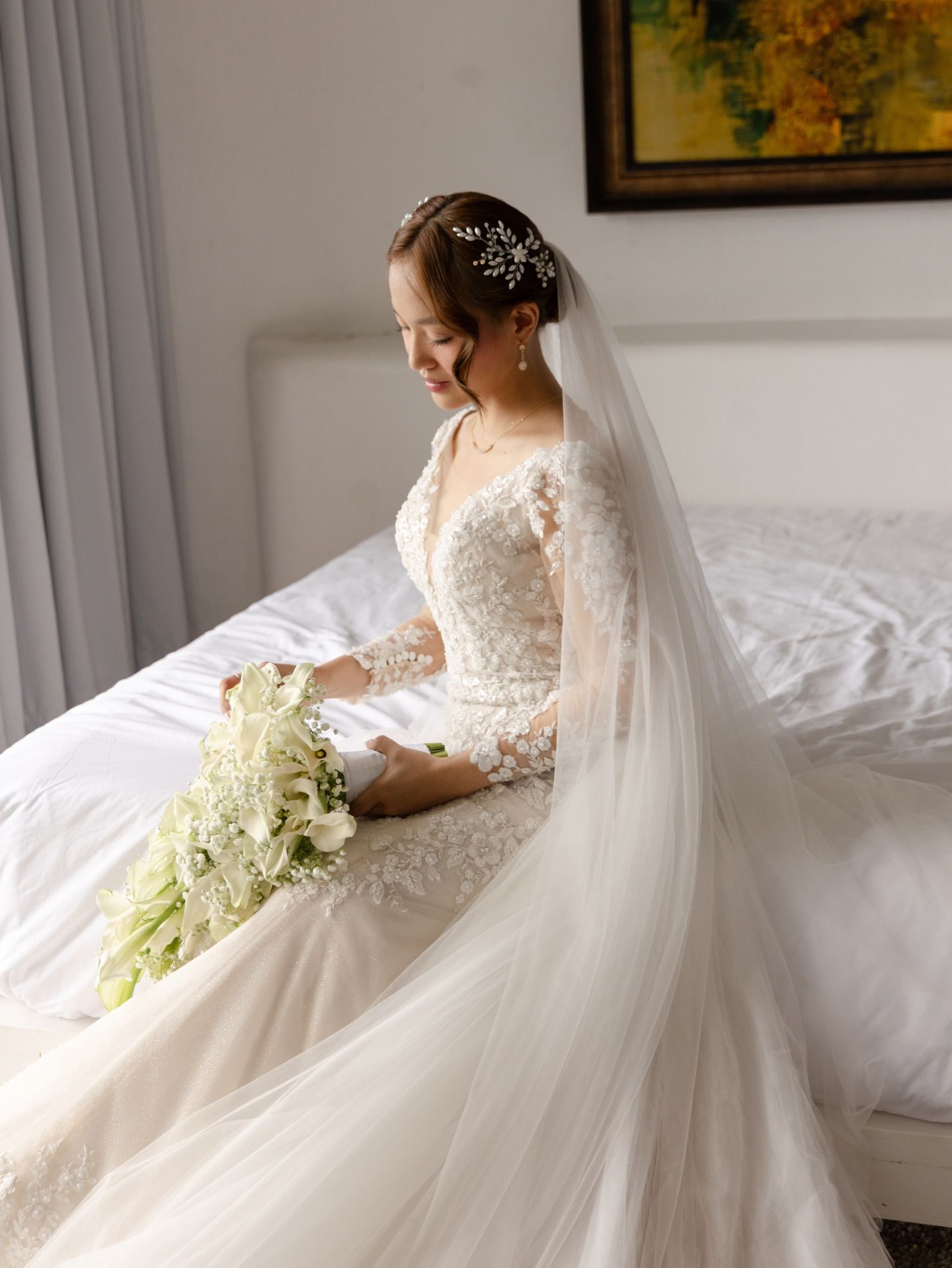 Bride sitting on bed (Back view): Modern compositions that push the boundaries of traditional wedding photography.