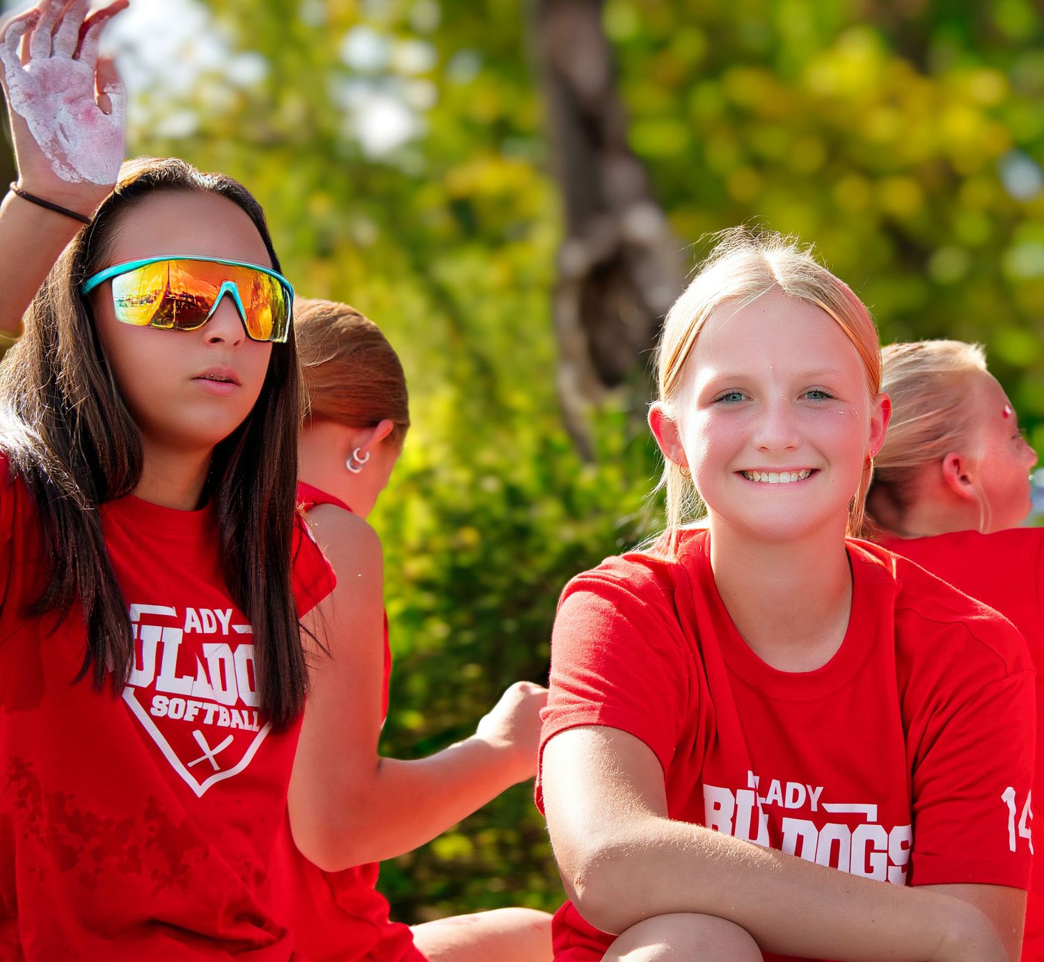 Two young cheerleaders in red and white uniforms standing together and smiling.