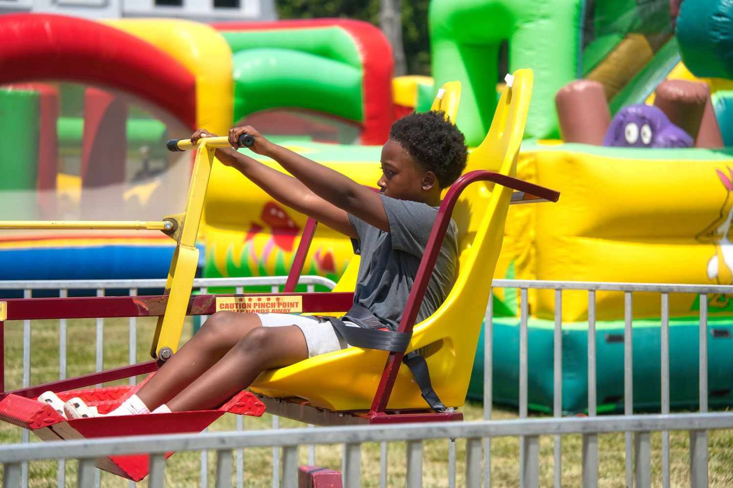 Two children, a boy and a girl, sit together on a carnival ride.