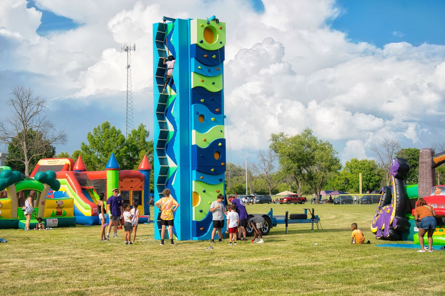 An outdoor carnival or festival scene with various colorful rides and attractions.