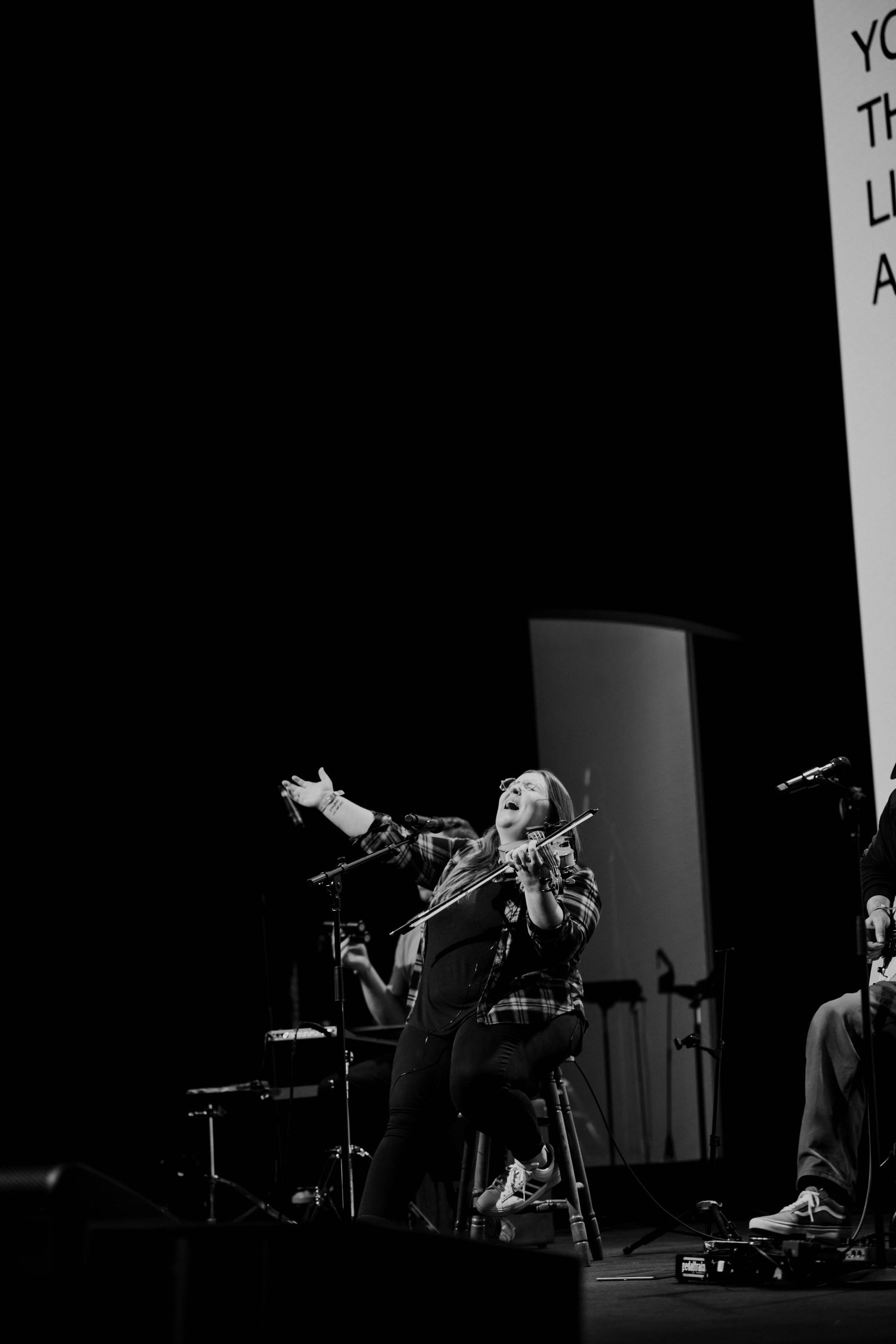 Black and white photo of a violinist performing passionately on stage.