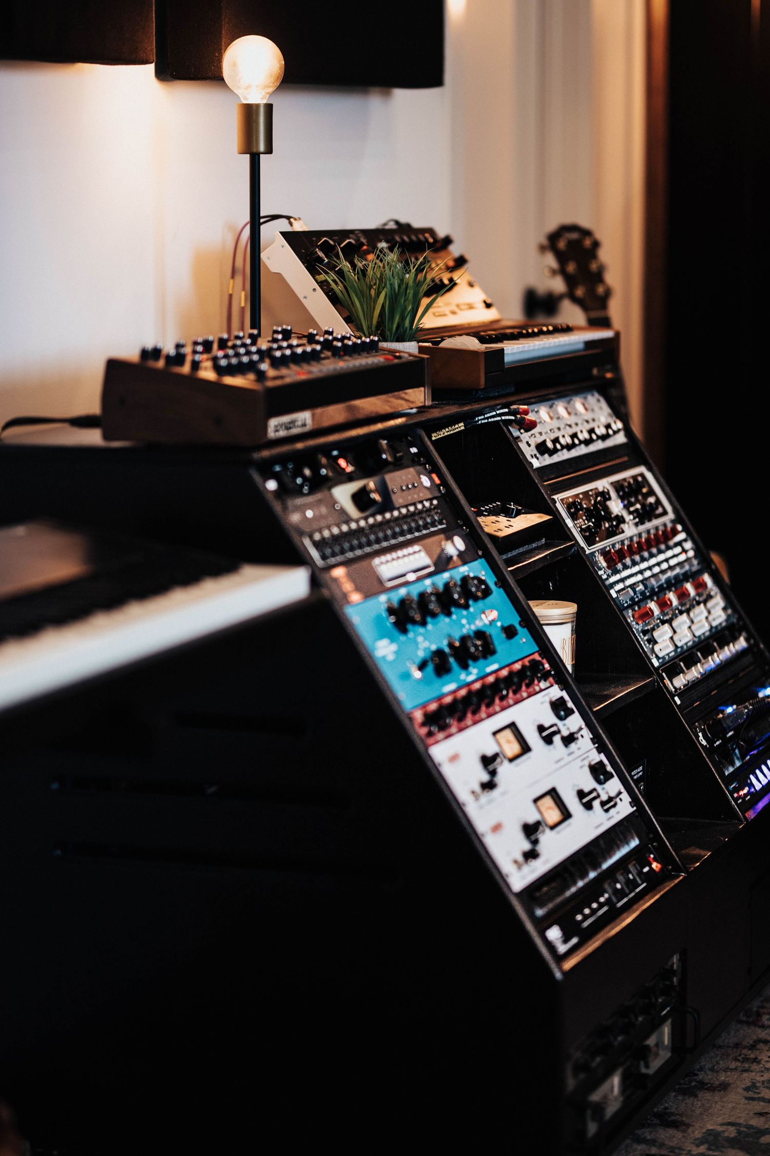 Professional music studio setup with synthesizers, modular rack, and keyboard instruments.