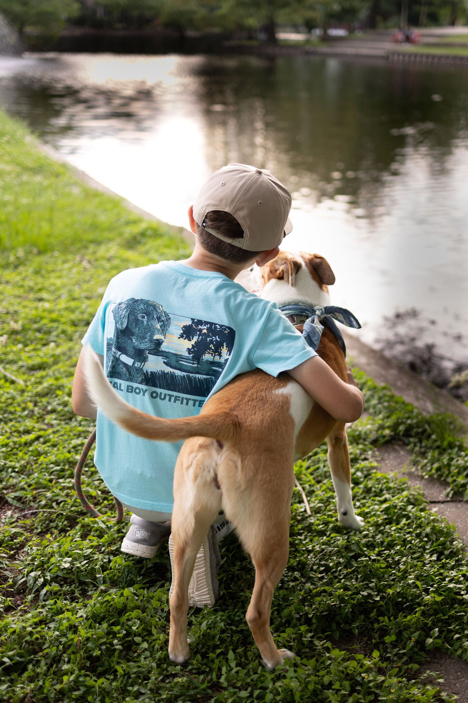 Young boy with arms around special needs dog.
