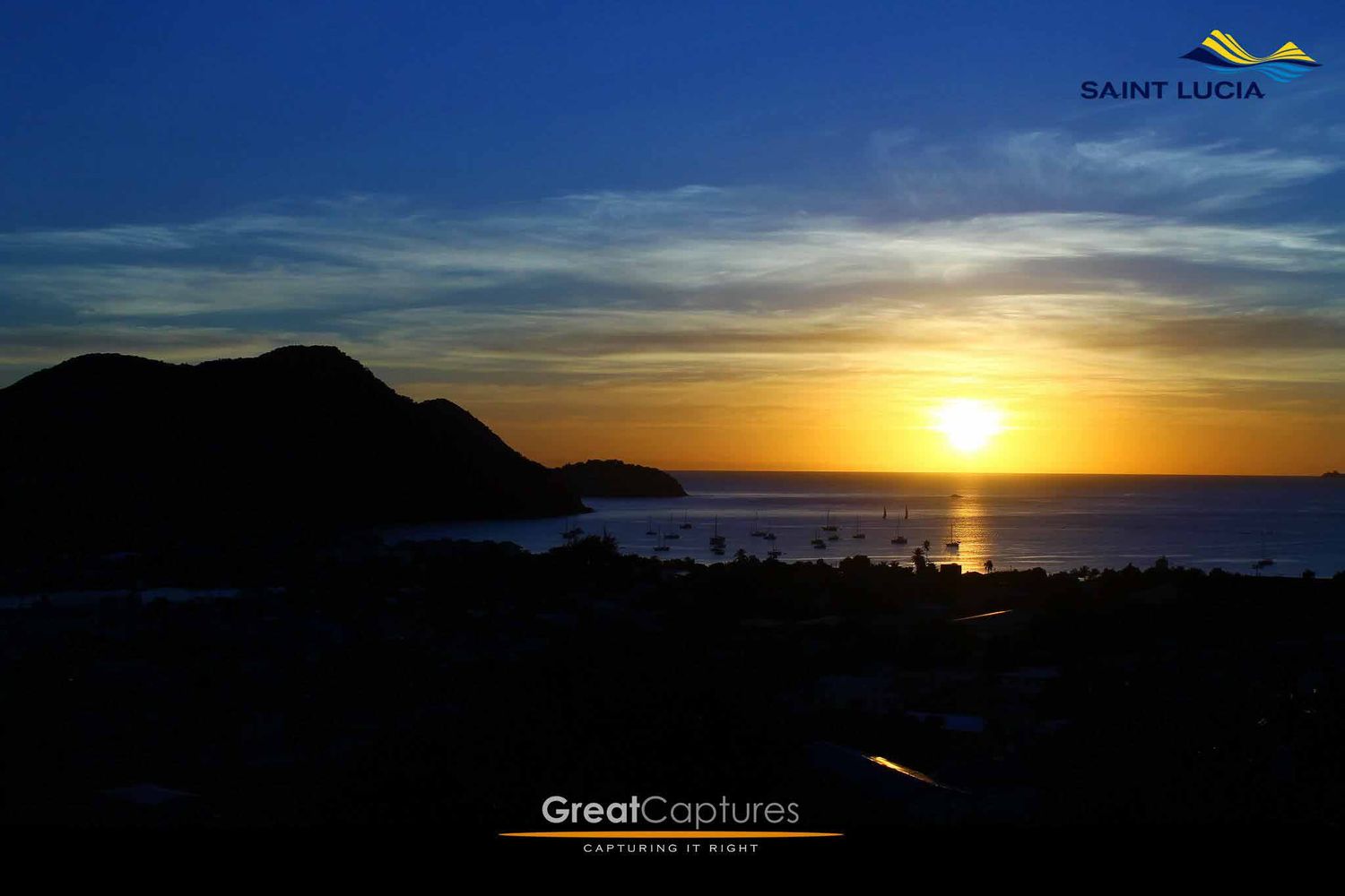 Stunning sunset over Saint Lucia coastline with golden sky, silhouetted hills, and calm ocean waters.