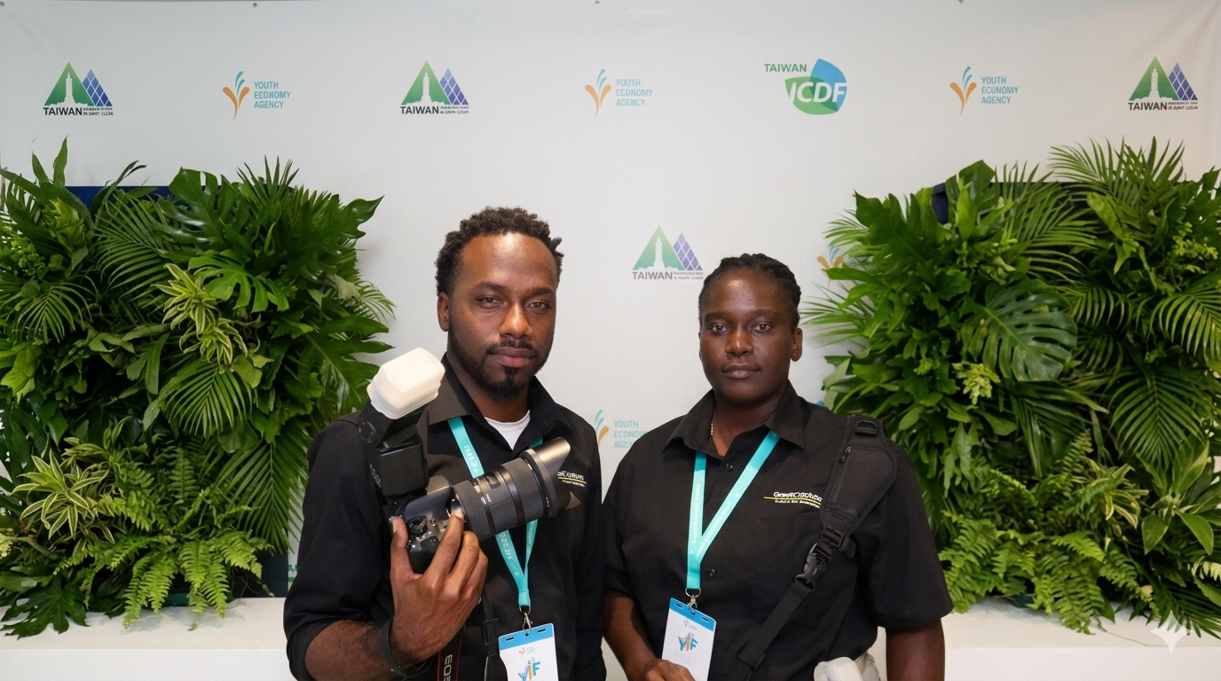 Two professional photographers in black shirts holding cameras at a branded Taiwan ICDF event backdrop.