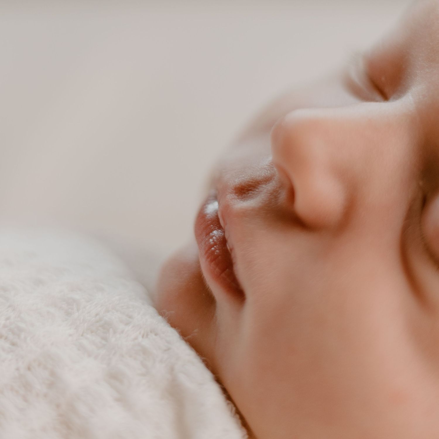 Extreme close up macro image showing serene facial profile details in soft pale colors and lighting.