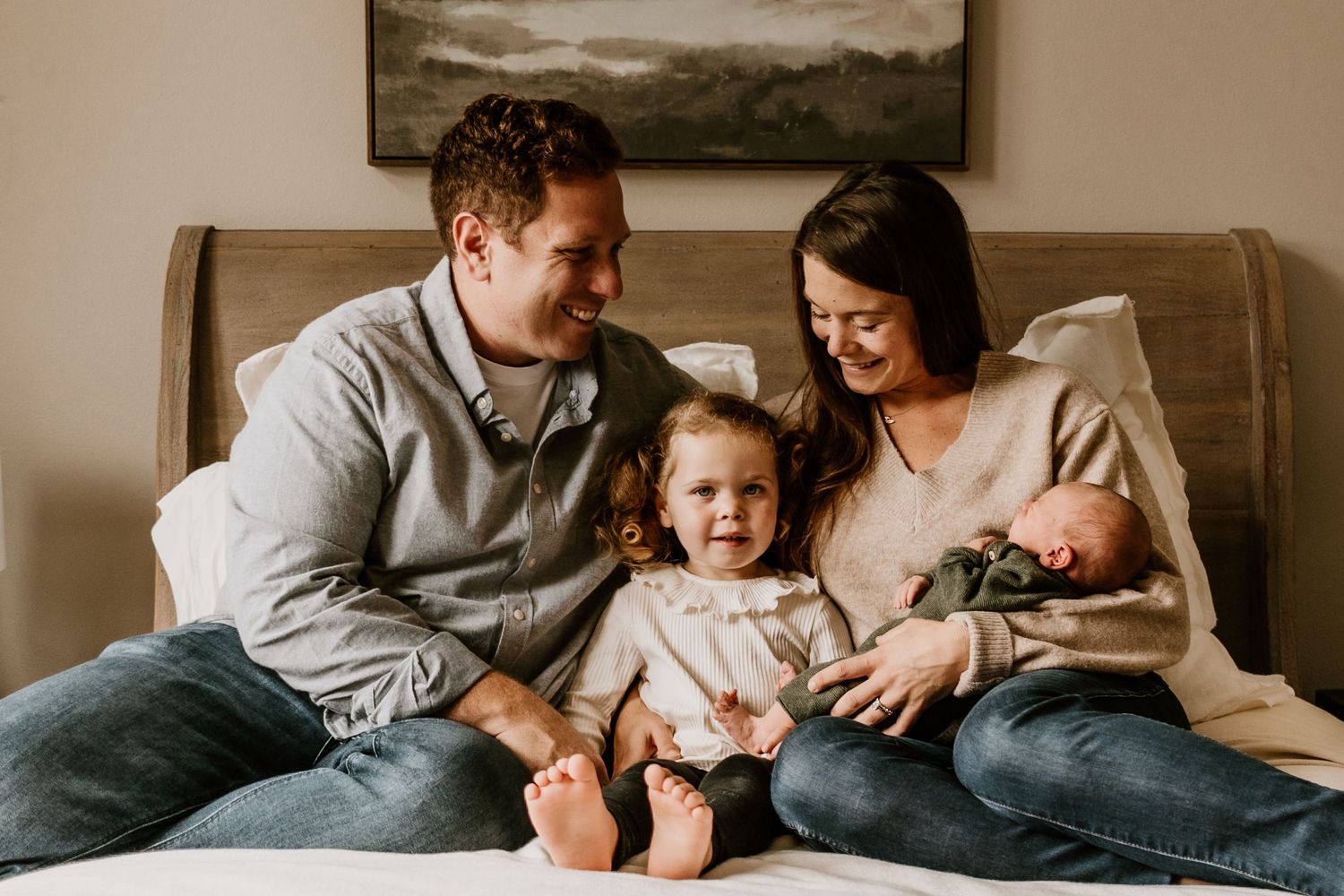 Family relaxing together on a cozy gray couch during an intimate lifestyle photography session.