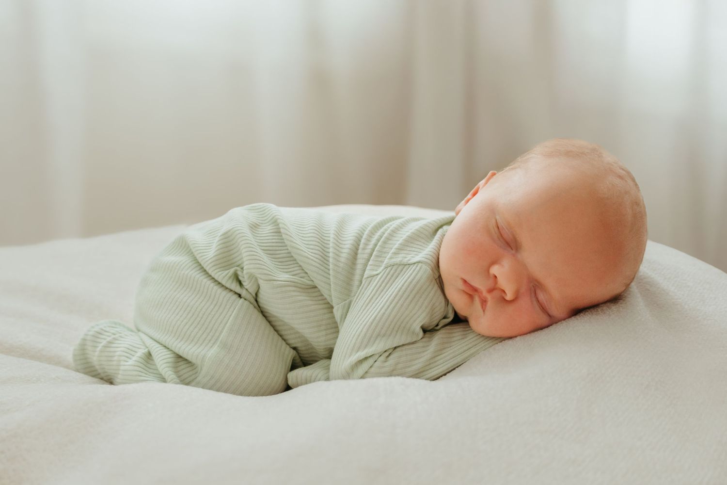 A series of peaceful images showing a sleeping baby in light green clothing on white bedding.