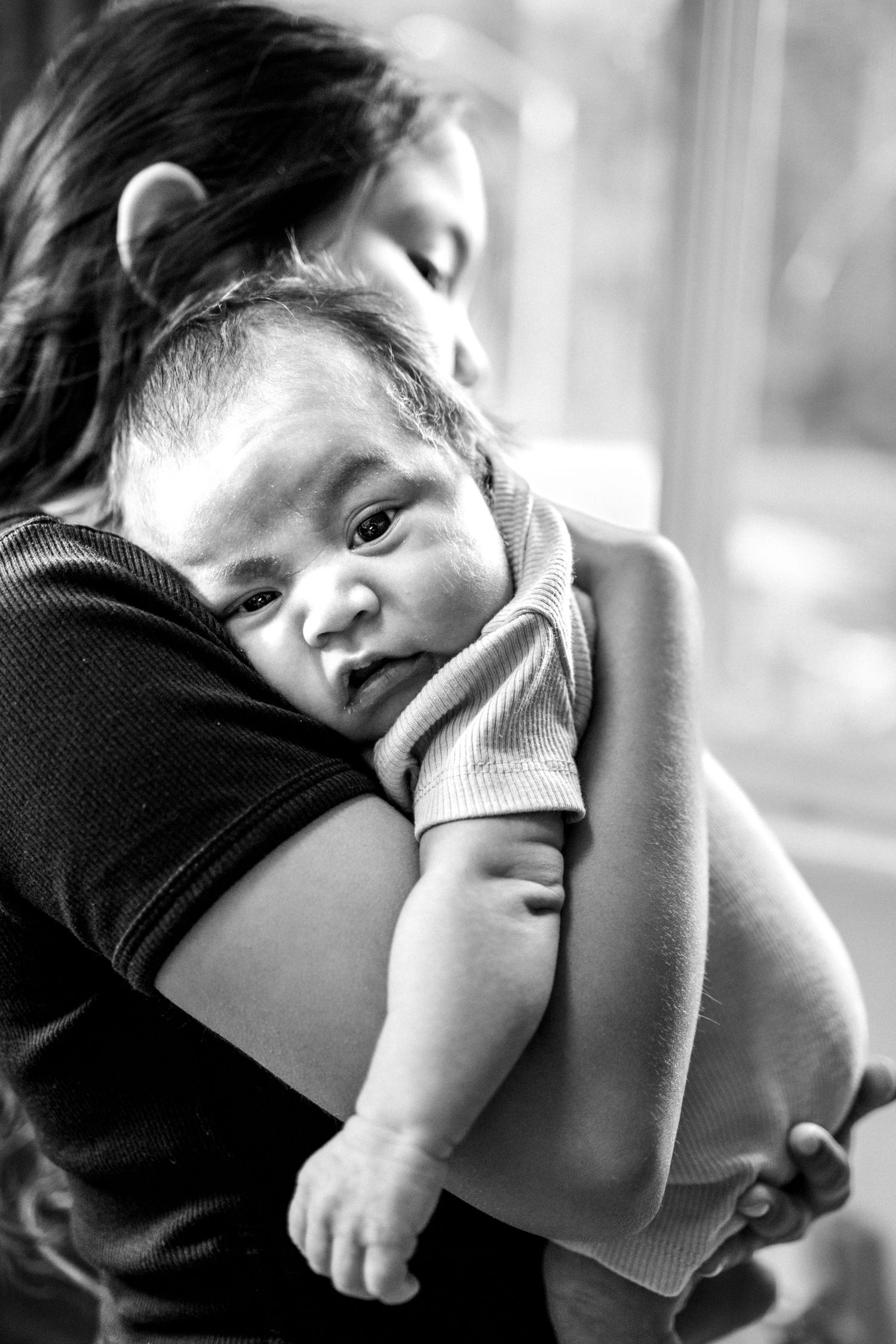 A series of black and white portraits showing a child resting their head on their arm in different angles.