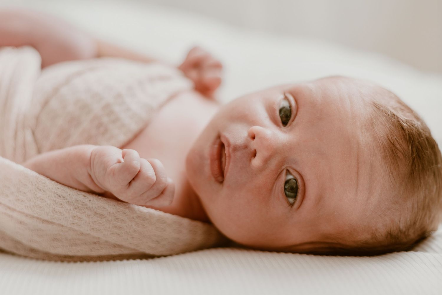 Artistic series of newborn baby photos showing peaceful sleeping poses on neutral backgrounds.