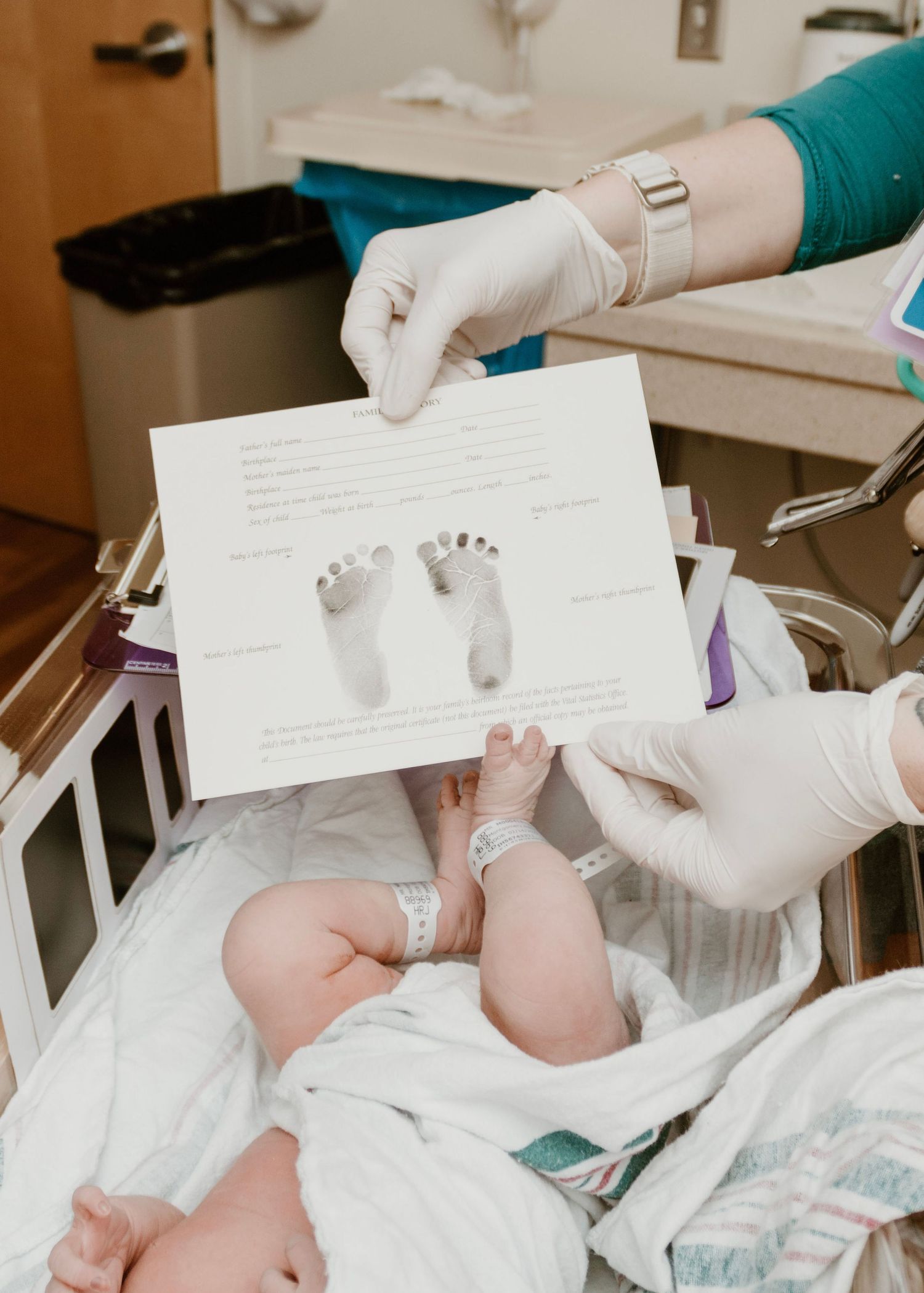 A medical professional taking footprints of a newborn baby in the hospital.