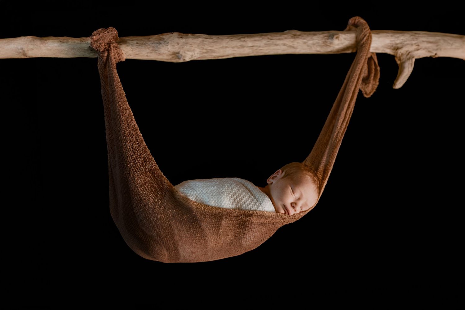 A sequence of dark images showing stages of a brown hammock swaying from left to right against a black background.