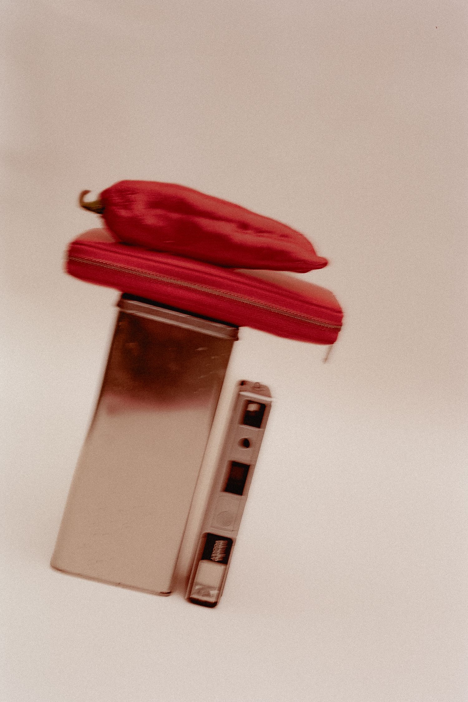 A sequence showing a red plastic lid being closed on a beige plastic container against a light background.