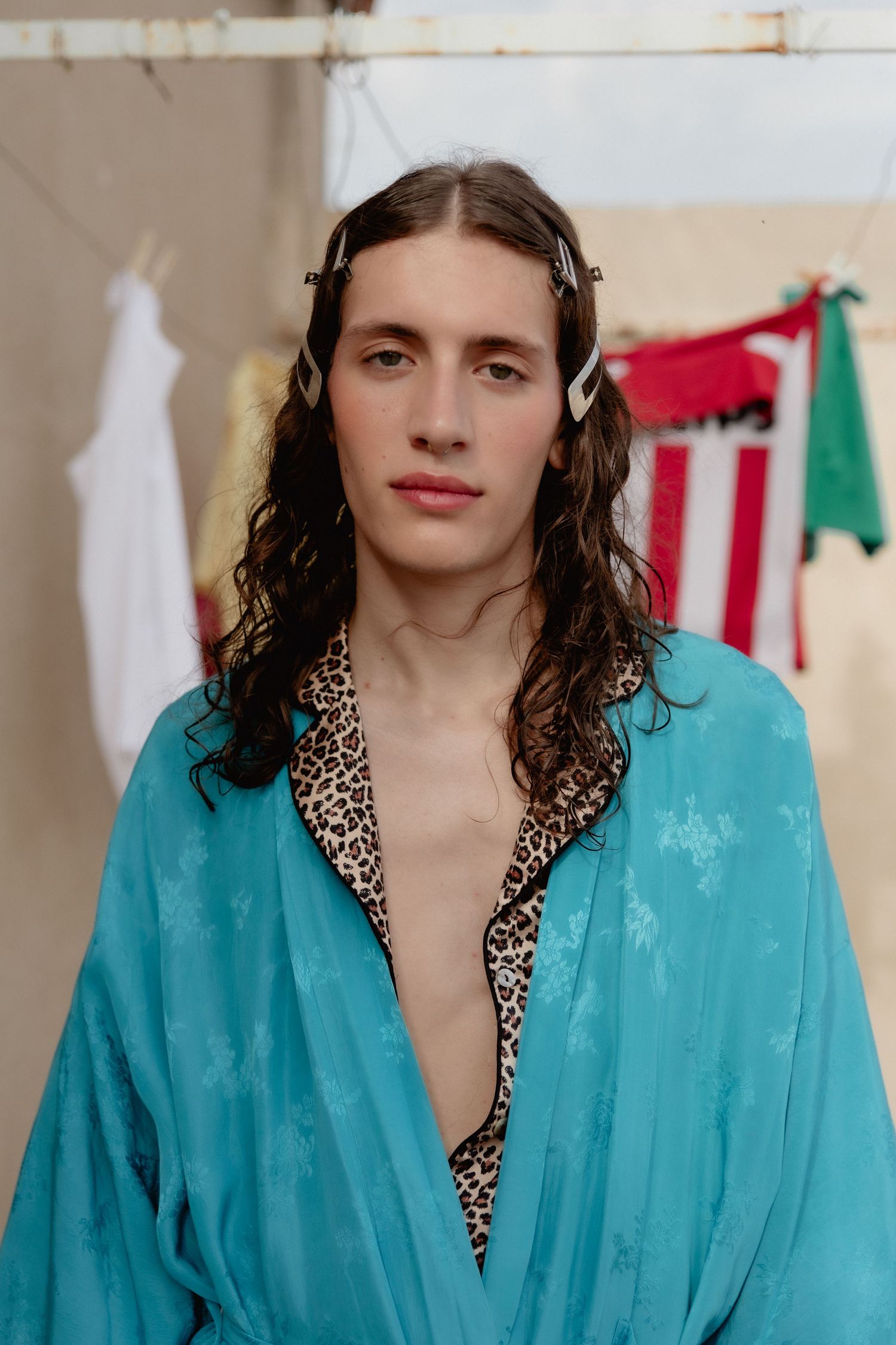 A sequence of fashion photos showing a model wearing a bright turquoise robe with leopard print trim against a white backdrop.